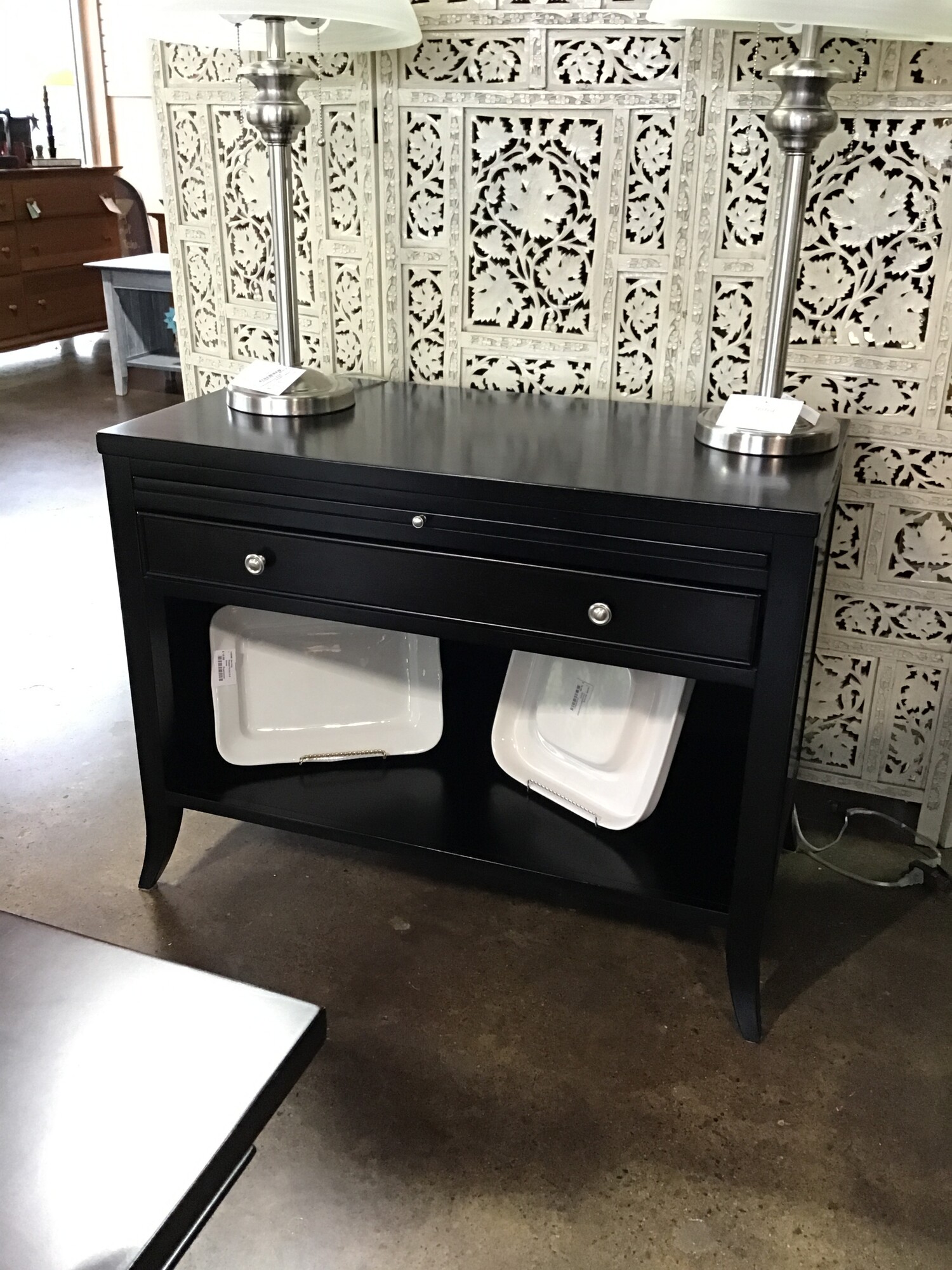 A modern classic, this Arhaus chests understated aesthetic features sleek silhouettes defined by clean lines and deep black  finish. Subtle nickel hardware elevates the style by complementing its black finish with sophisticated detailing.  This piece has a pull out shelf that can be used to write on or as a spot by your bed to put a drink.  There is a drawer and a deep space below to hold so many different things!

Dimensions:  38 x 19.5 x 29.5