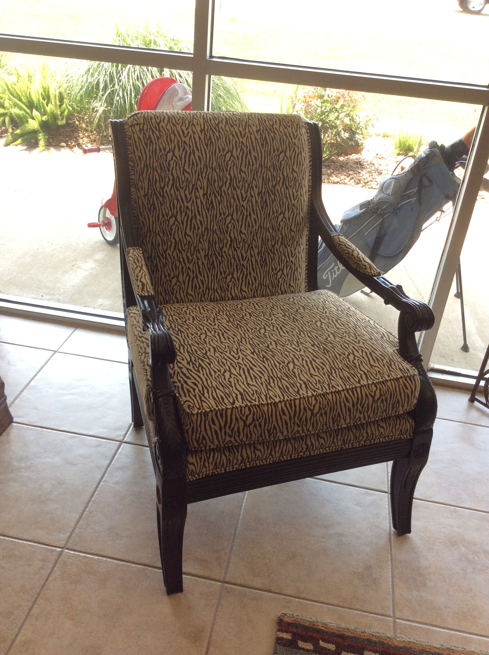 This is a Brown and Cream Zebra Accent Chair. This Chair has Dark Wood Stained detailed arm and foot rails.