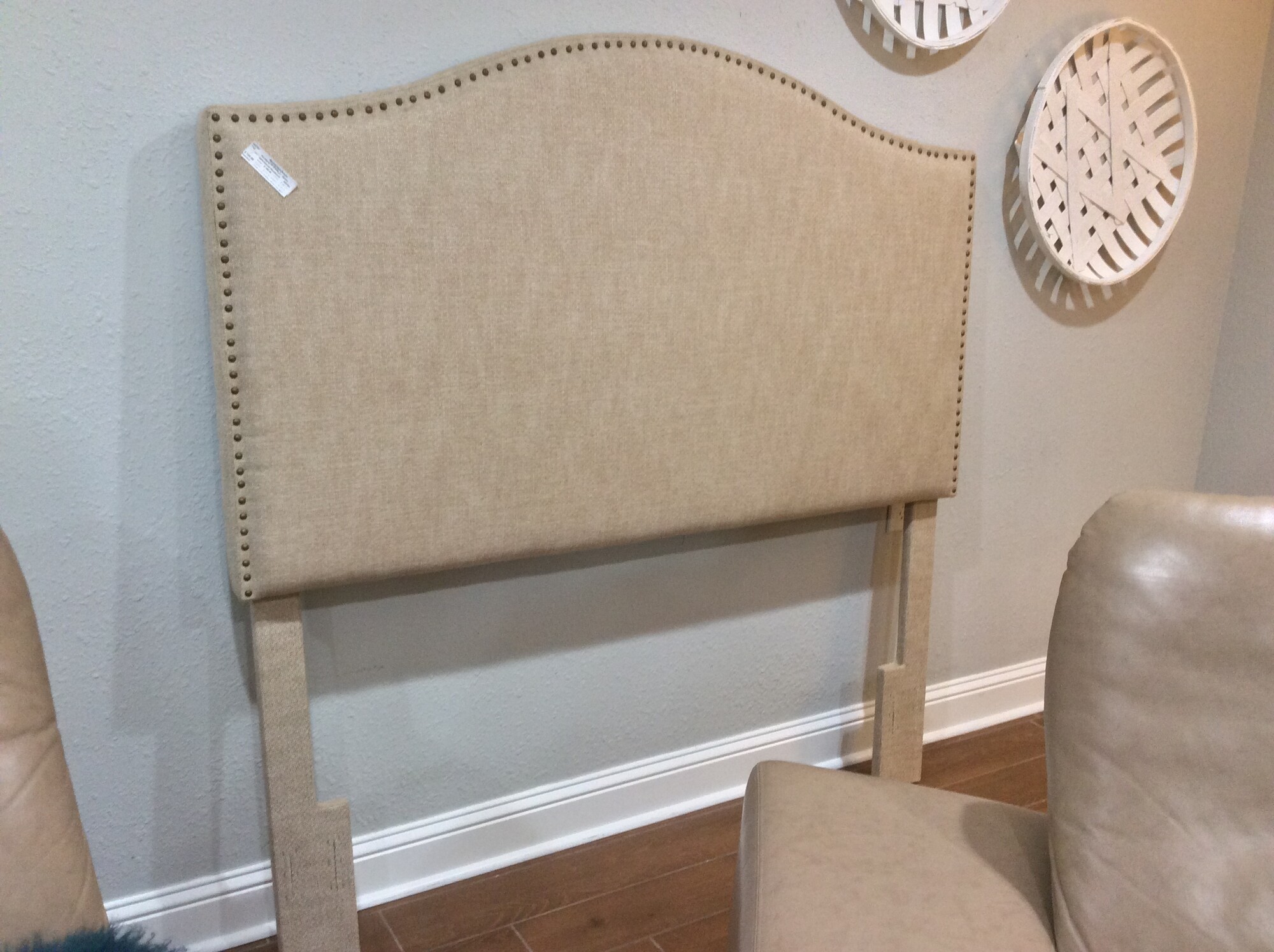 This is a Home Meridian Tan Upholstered Queen Headboard. This headboard has rustic nailhead trim.