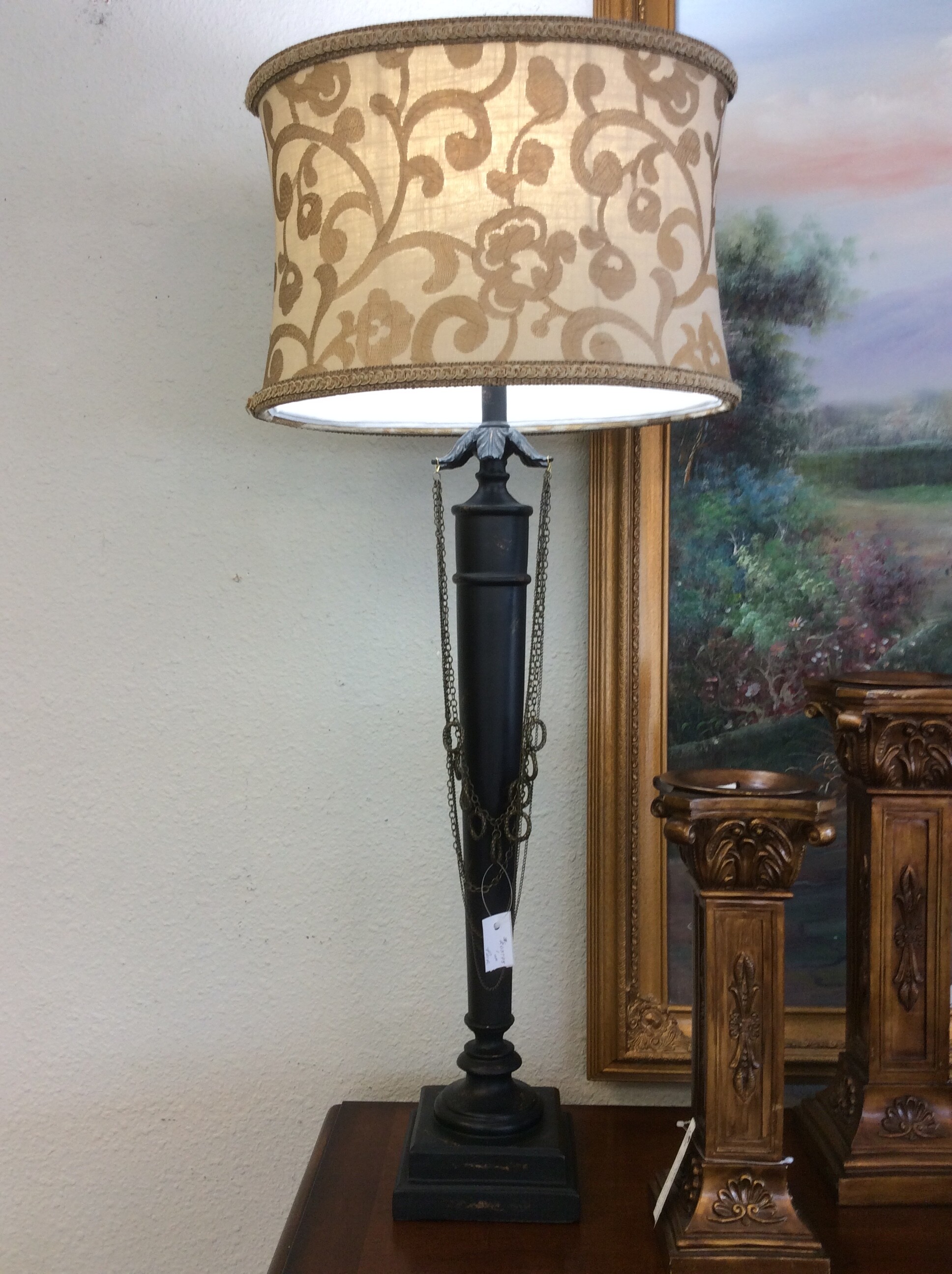 These Tall Buffett Lamps are a beautiful distressed dark stained wood. They have a unique bronze necklace type chain haning down in front and pretty cream & tan shades.