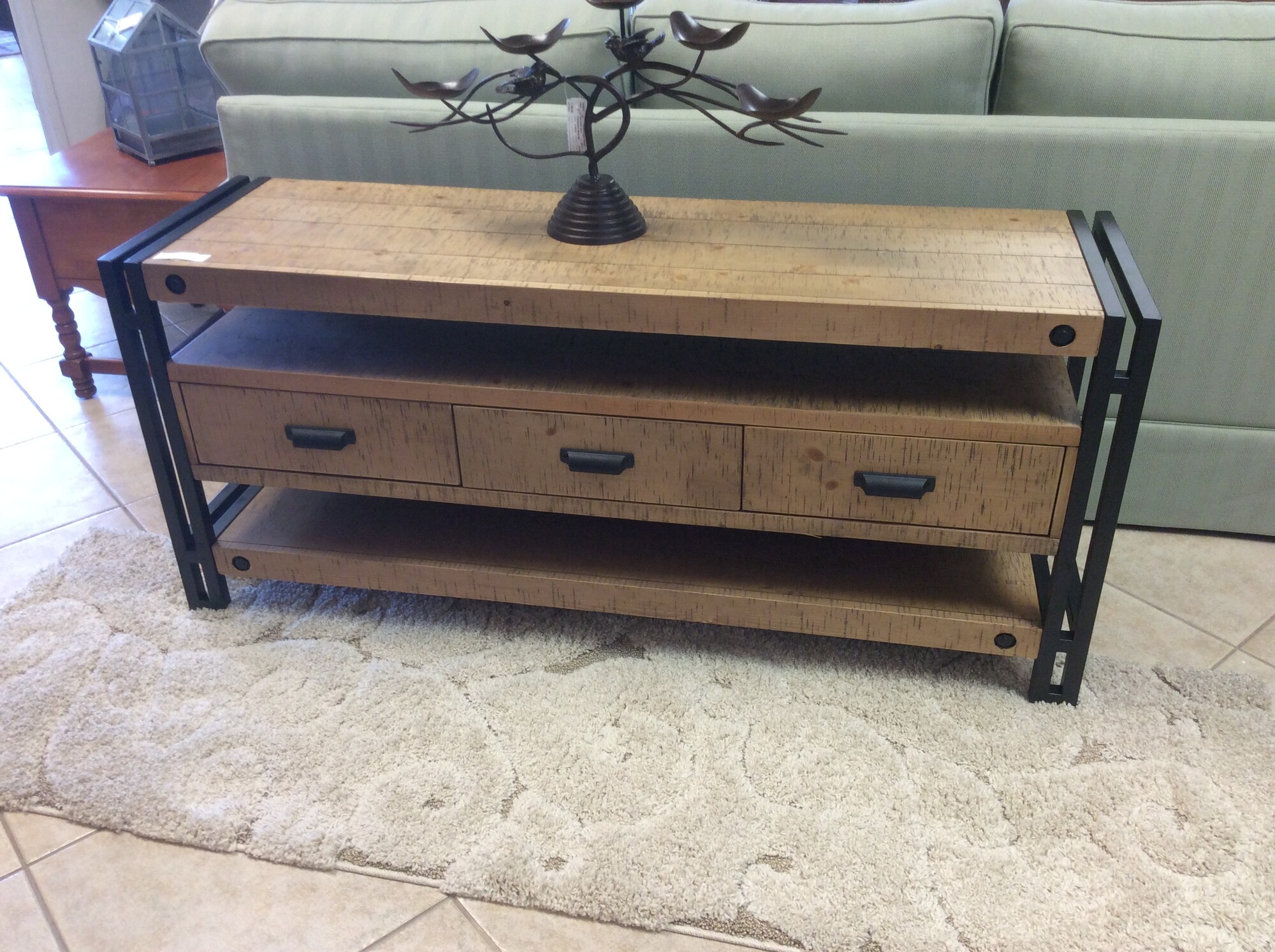 This is a Distressed Wood TV Table. This TV Table has Black Iron Legs, 3 Drawes and 3 Shelfs for plenty of storage.