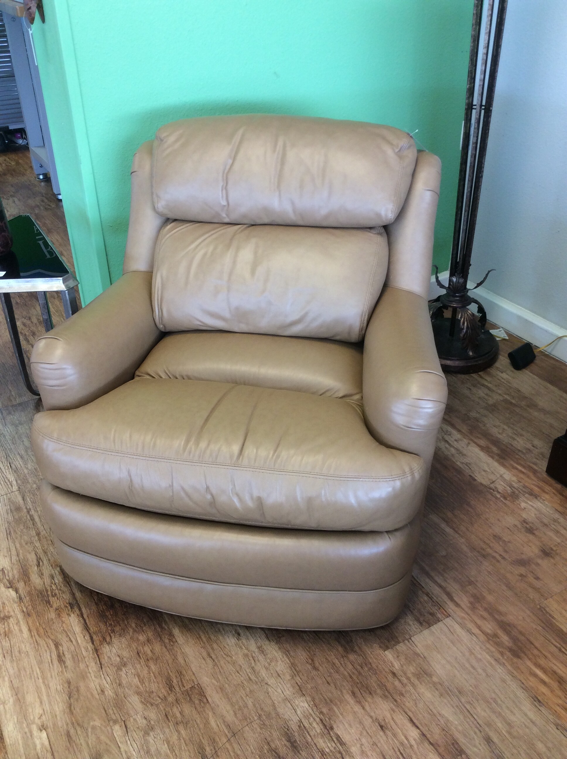 This comfy  chair is upolstered in a soft tan leather.  Could be used in a variety of settings.