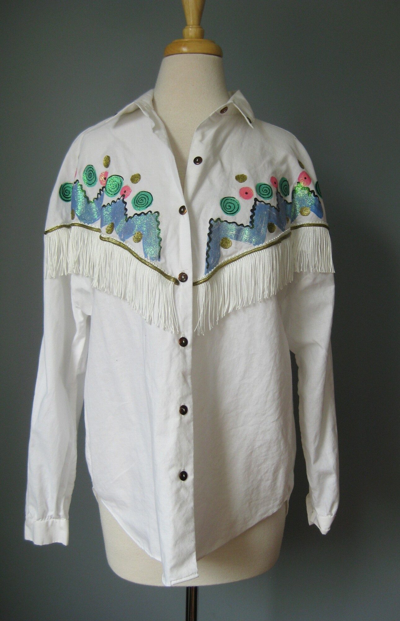 Vtg 80 Box Office, White, Size: XL
Fun, somewhat western style white blouse by Box Office, made in the 1990s.
It's got white fringe across the chest and a glittery blue and pink design painted on the front, a couple of jewels too.
The back is plain.
assembled in Mexico
100% cotton

excellent condition
Marked size 16/18
flat measurements:
shoulder to shoulder: 24
armpit to armpit: 23.5
underarm sleeve seam: 16.5
length: 26.25

thanks for looking!
#42873
