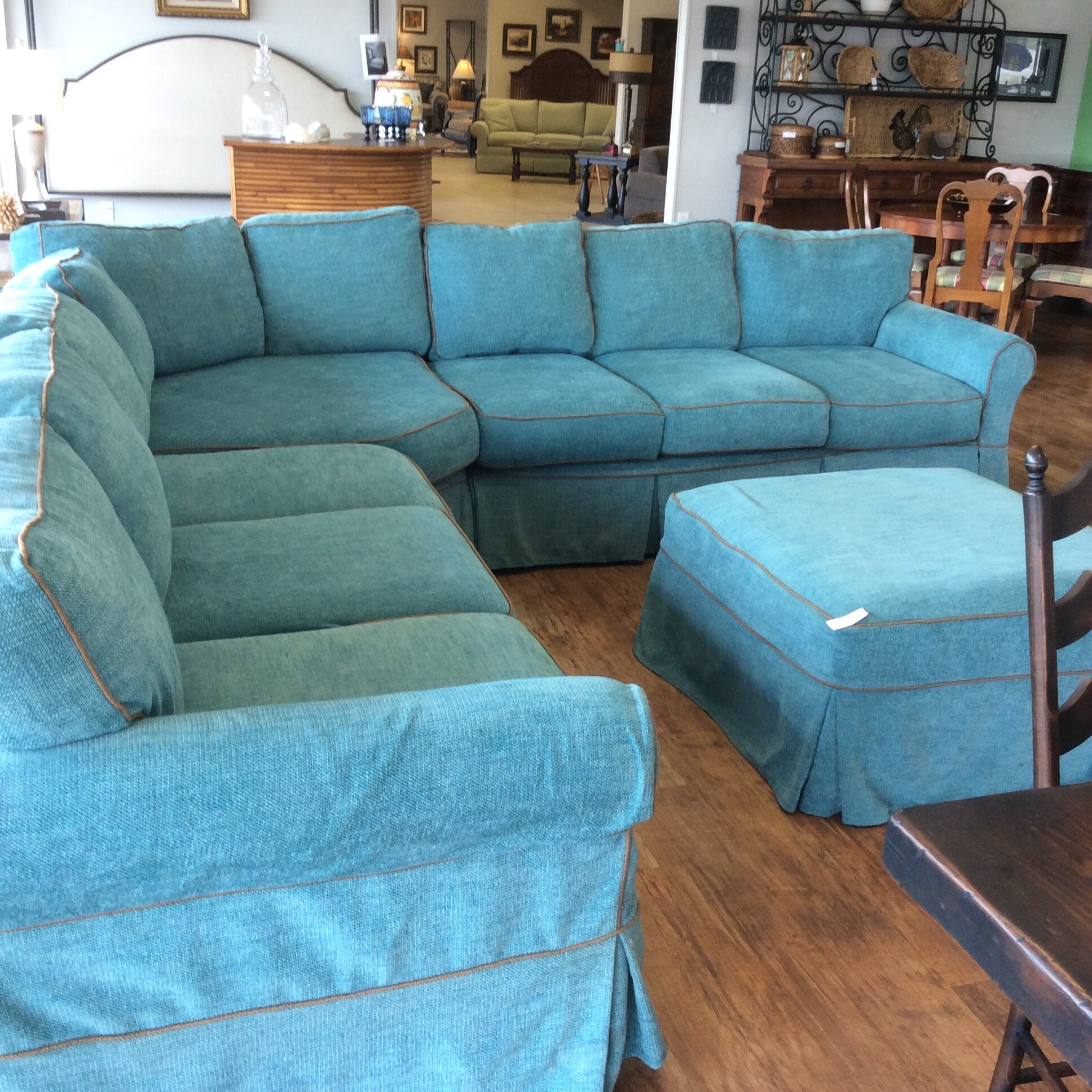 This large custom L shaped couch offers ample seating as well as comfort,. It's slip covered in a blue tweed fabric for easy cleaning.