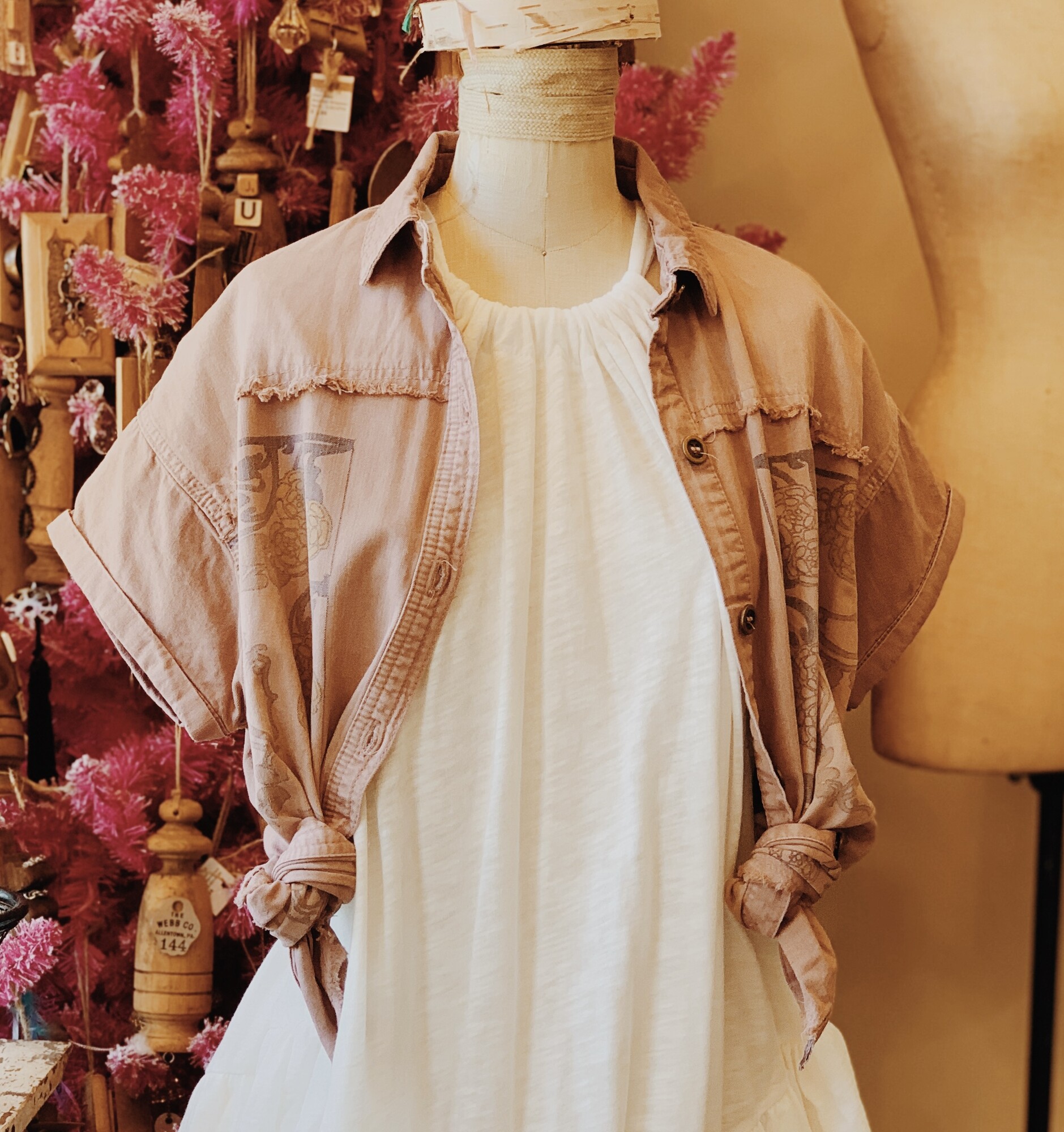 This gorgeous mauve shirt is madeof a denim material and has a lovely floral pattern on the front!