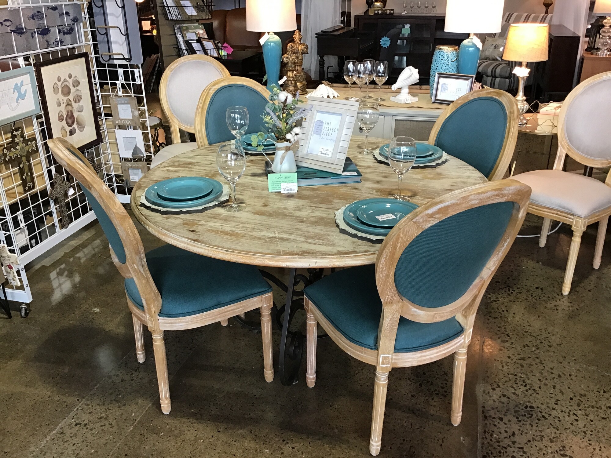 This beautiful round table has a driftwood finish on the table top and a beautiful metal iron base. The chairs have the driftwood frame and the seats and back are upholstered in a gorgeous teal fabric. This set is simply gorgeous!

Table Dimensions are 54 in x 31 in
Chair Dimensions are 21 in x 19 in x 40 in