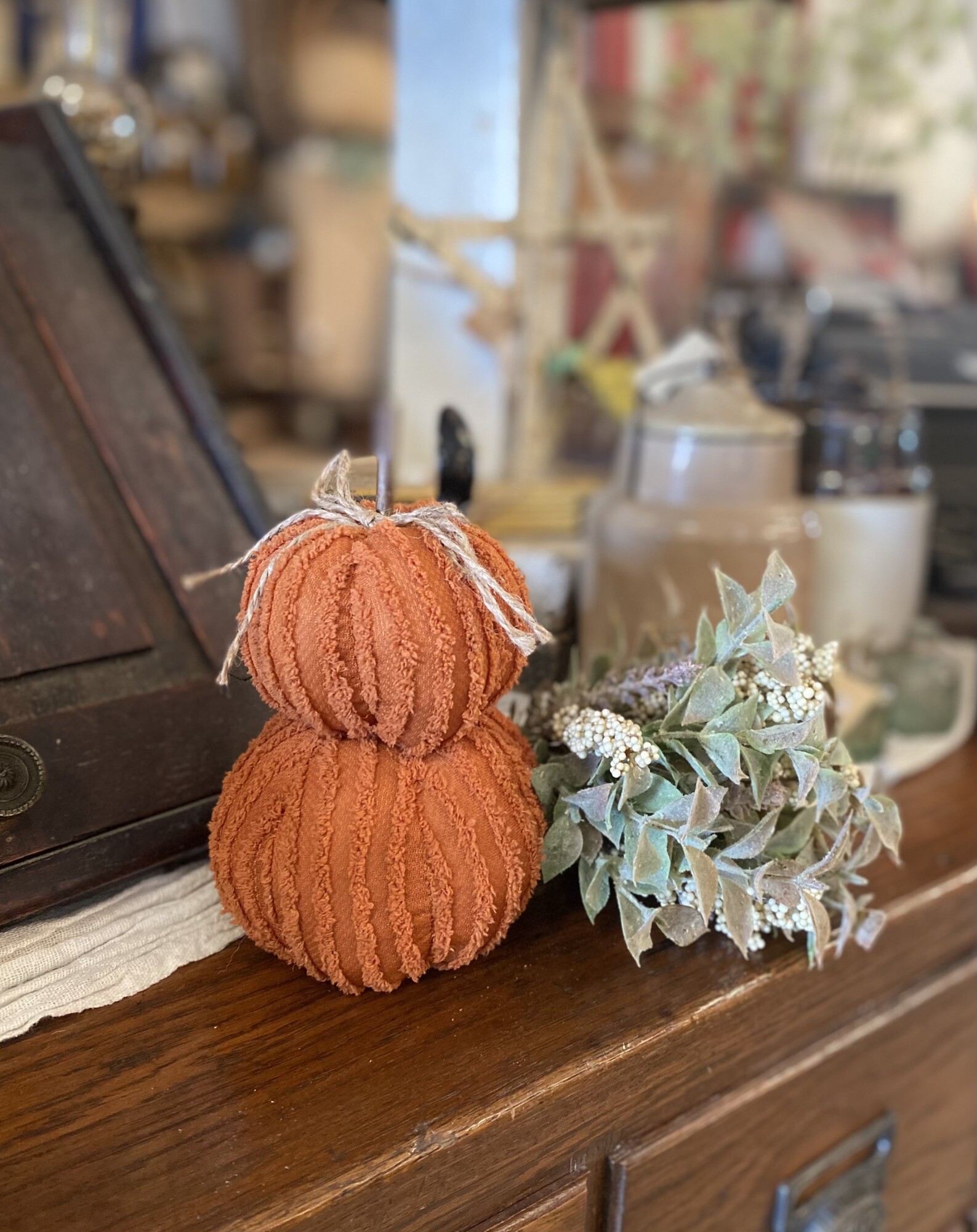 Mini orange pumpkin stack is made of soft chenille fabric in a burnt orange color and looks great displayed in bowls; baskets; or table tops.  The top of the stack has a stick stem with a jute bow and it measures 7.25 inches tall by 5 inches wide at base