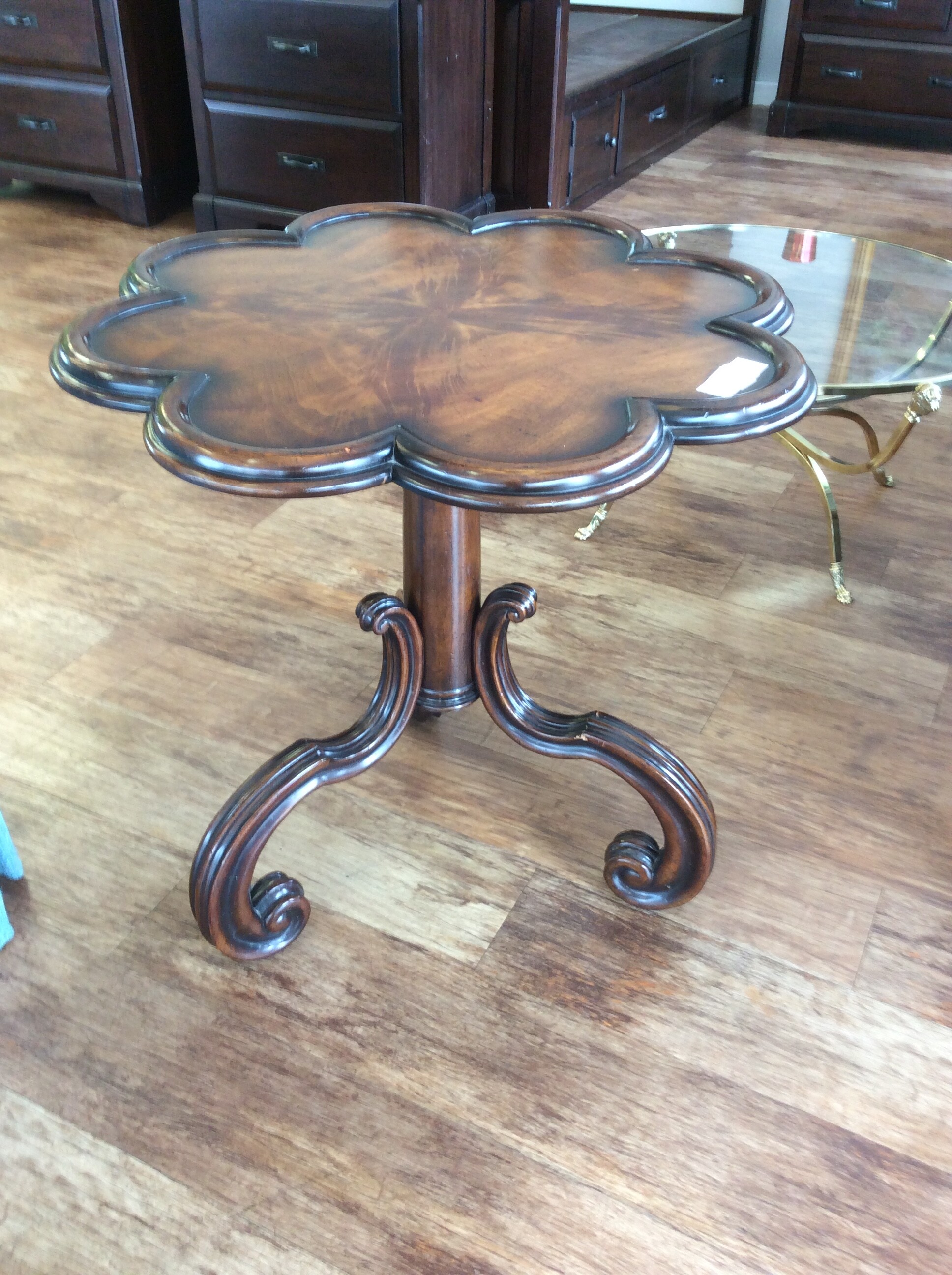 This unusual side table has a scalloped top and a carved tripod base.