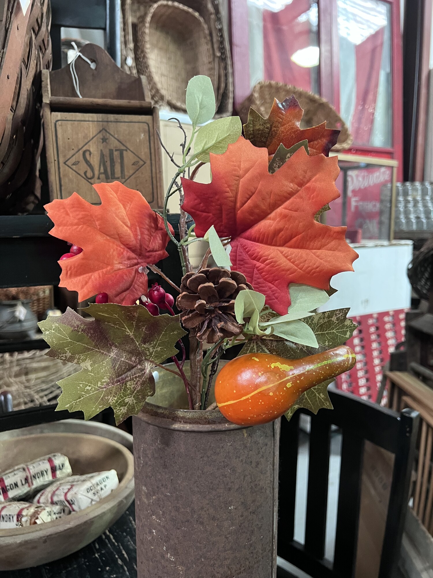 This festive maple leaf and gourd stem is the perfect fall floral. The stem measures 19 inches tall and has beautiful silk maple leaves, foam berries, a pine cone and a foam gourd wrapped in brown floral wrap