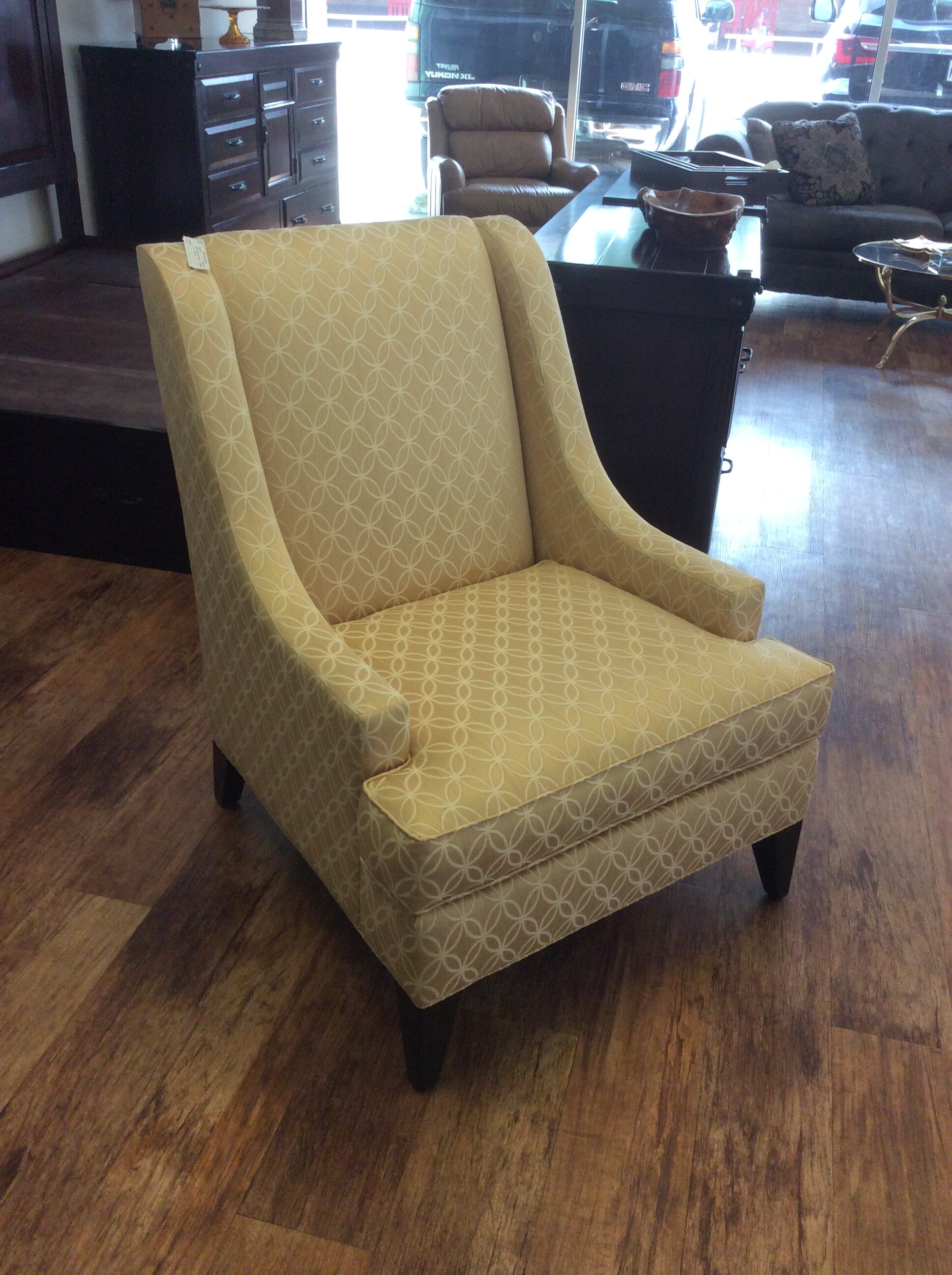 This is a buttercream and ivory Ethan Allen accent chair. This chair has a beautiful circle and diamond pattern and dark brown legs.