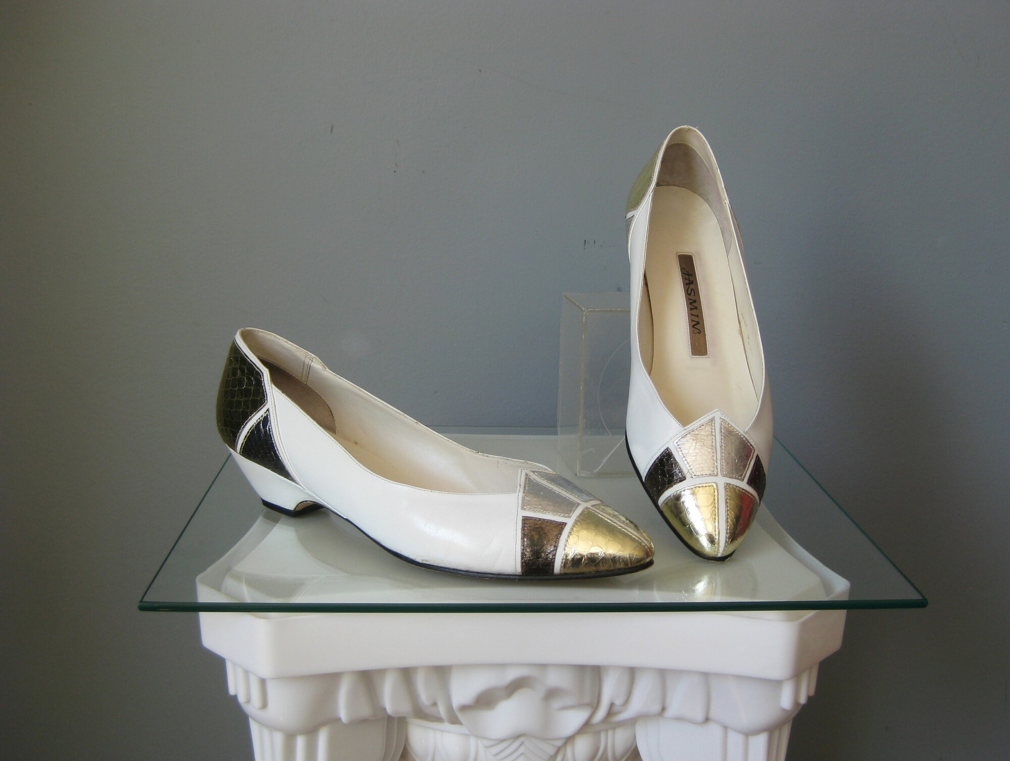 Vtg Jasmine Flats, Goldwh, Size: 8
This pair of low heeled pumps from the 1980s is by Jasmin.  They're high quality and give a lot of versatility by successfully mixing gold and silver metallics with the over all white leather body.
This model is called Electric and they're size 8
Made in Hong Kong

Excellent condition with almost no wear, just a teeny bit of dirt near the bottom edge on one of the shoes.

Heel: 1.5
Insole length:9 3/4
Insole width: a shade over 3 at the widest spot

PLEASE NOTE: the box is shown for information documentation purposes ONLY I will not be shipping these with their box as it was not in the same great shape as the shoes.

Thanks for looking!
#45255