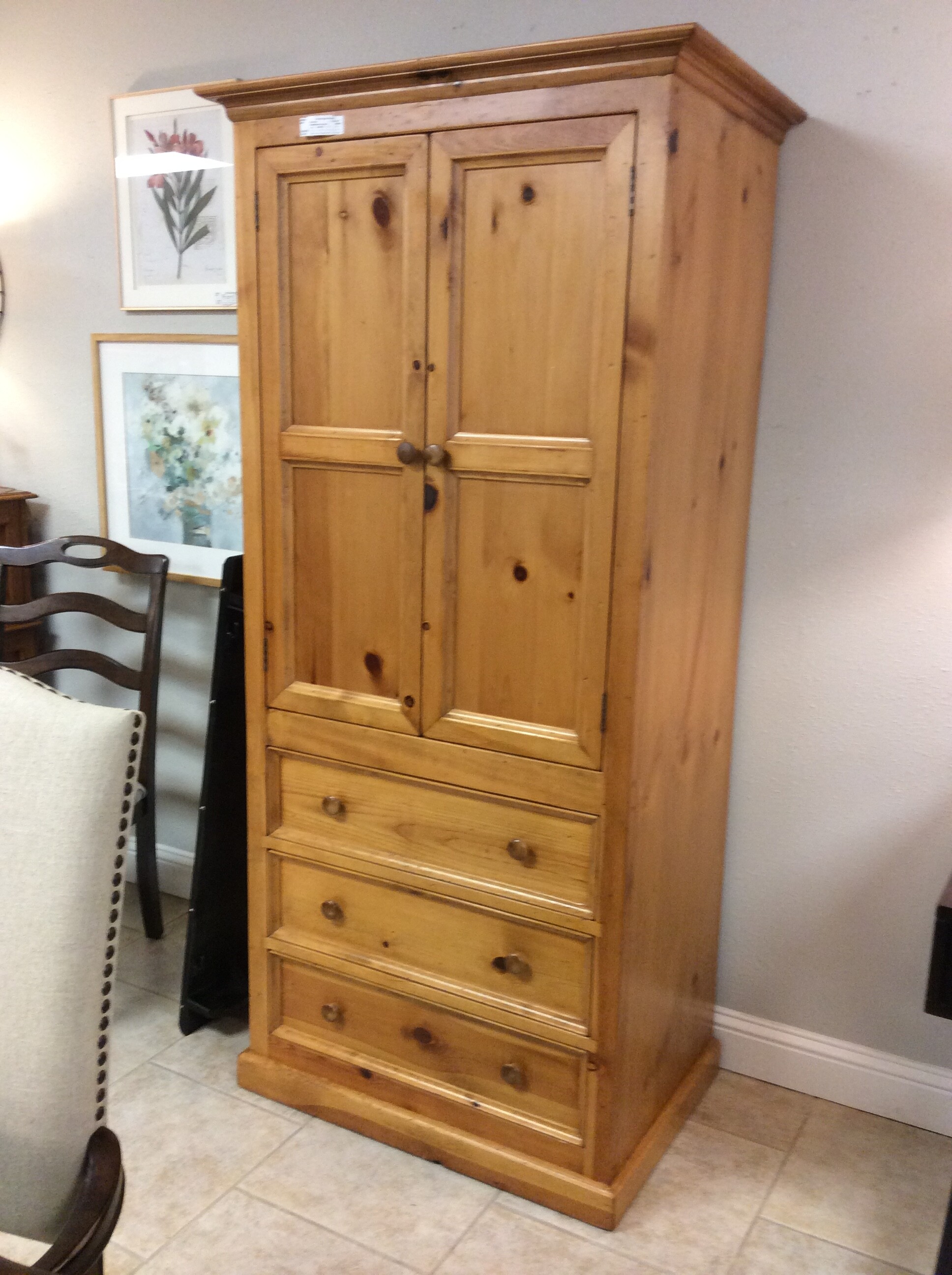This is a Pine wood, Eddie Bauer Armoire. This armmoire has a cabinet with 2 shelfs and 3 drawers.