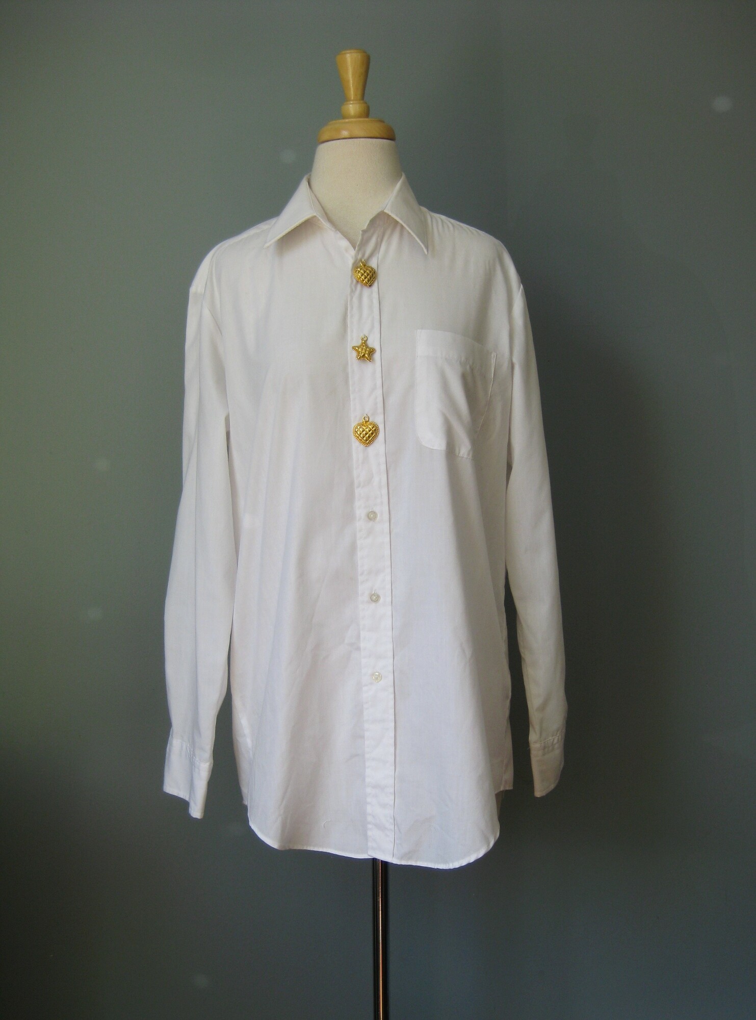 Vtg Cache, Wh/Gold, Size: Medium

This is a fun white blouse with a little something extra.
By Cache ( Gold Label!)
White cotton poly blend
Embellished with three substantial gold tone metal charms on the button placket.
Two hearts and a star in the middle.
Made in Korea
Marked size M
Flat measurements:
shoulder to shoulder: 16.5
armpit to armpit: 22.5
width at hem: 21.75
underarm sleeve seam length: 19
length : 31.5
Excellent condition!

thanks for looking
#43165