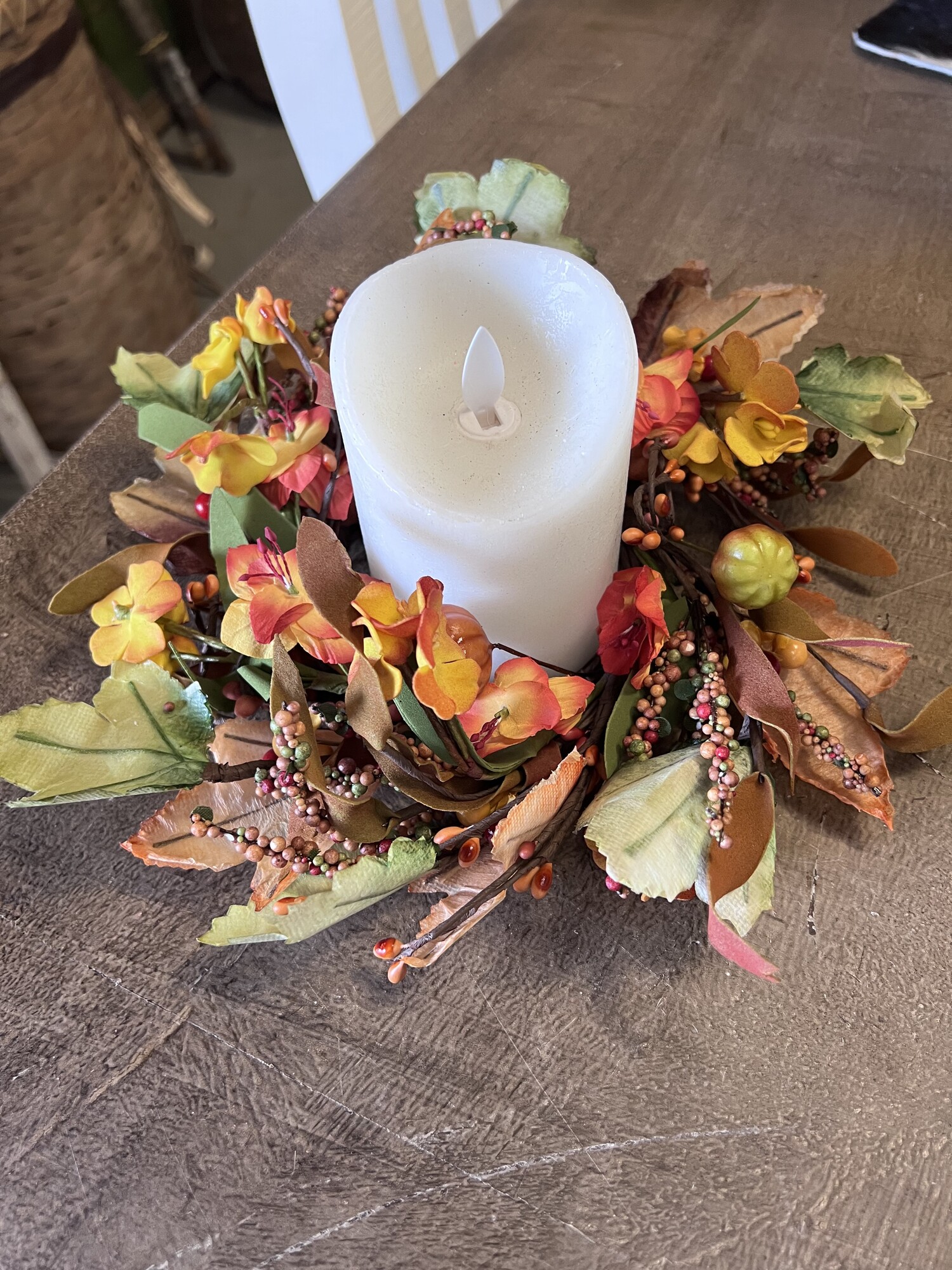 Harvest Garden ring has fall flowers combined with mini pumpkins,  pips,  berries,  leaves and spirals. Pair it with a jar or pillar candle for a pretty fall look.  Ring has an inside diameter of 4 inches and is approximately 10 inches outside