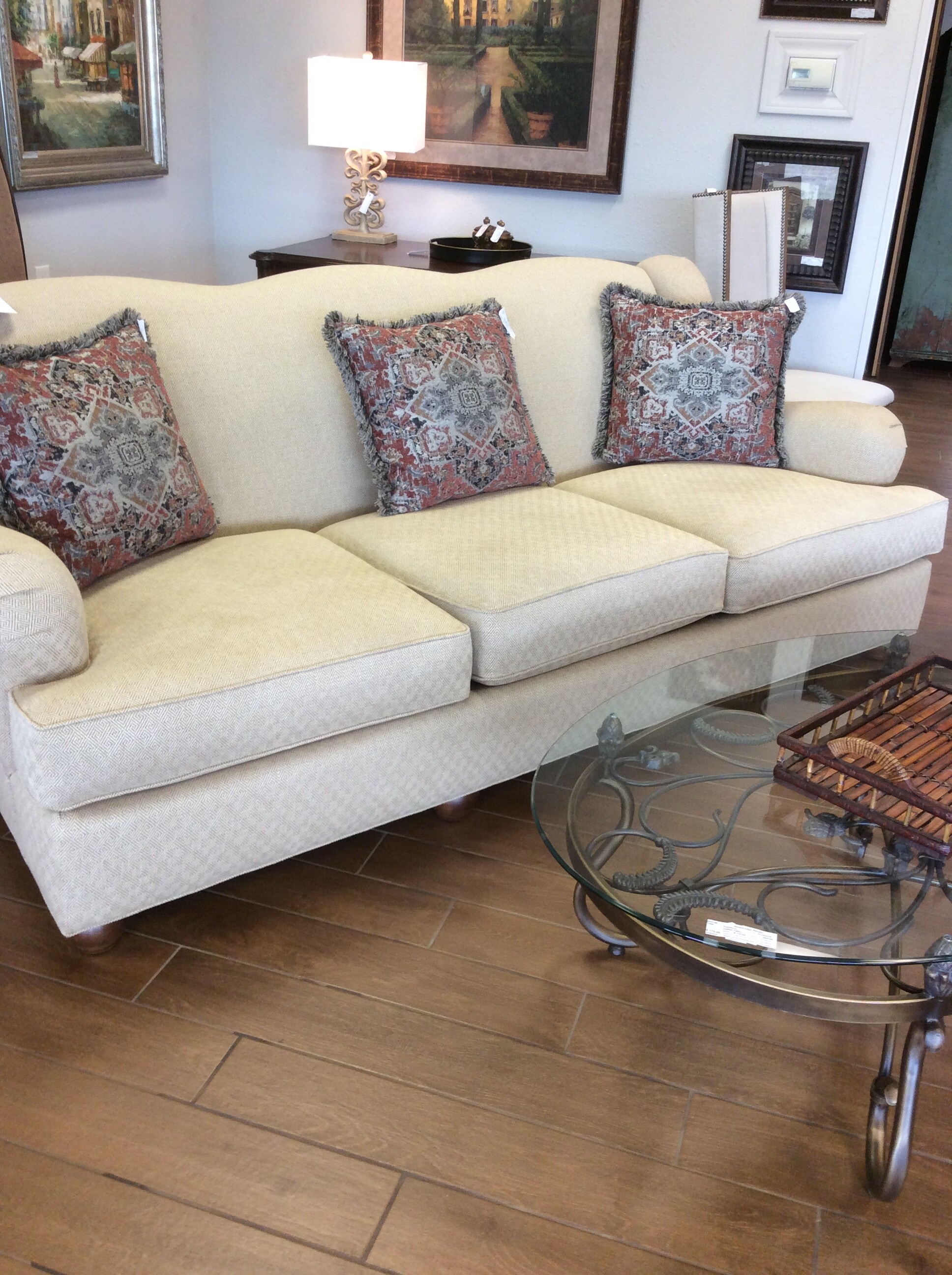 This sofa is covered in a butter cream colored fabric with a small tone on tone geometric print.