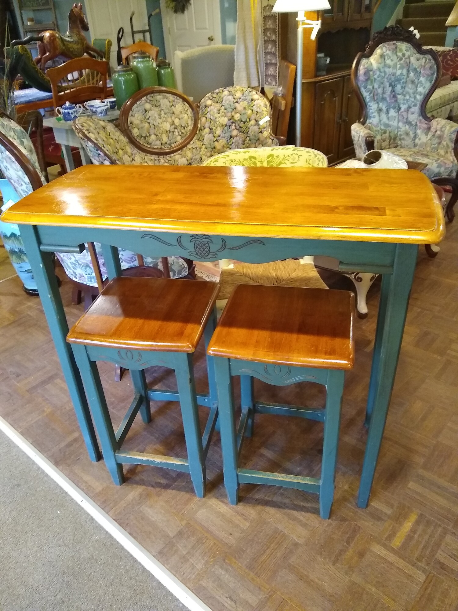 Breakfast Bar W/2 Stools

Wood breakfast bar with 2 saddle stools.  Wood top with green legs on both the bar and stools. Carved pineapple design on bar and carving on stools also.

Size: 41 in wide X 17 in deep X 36in high
