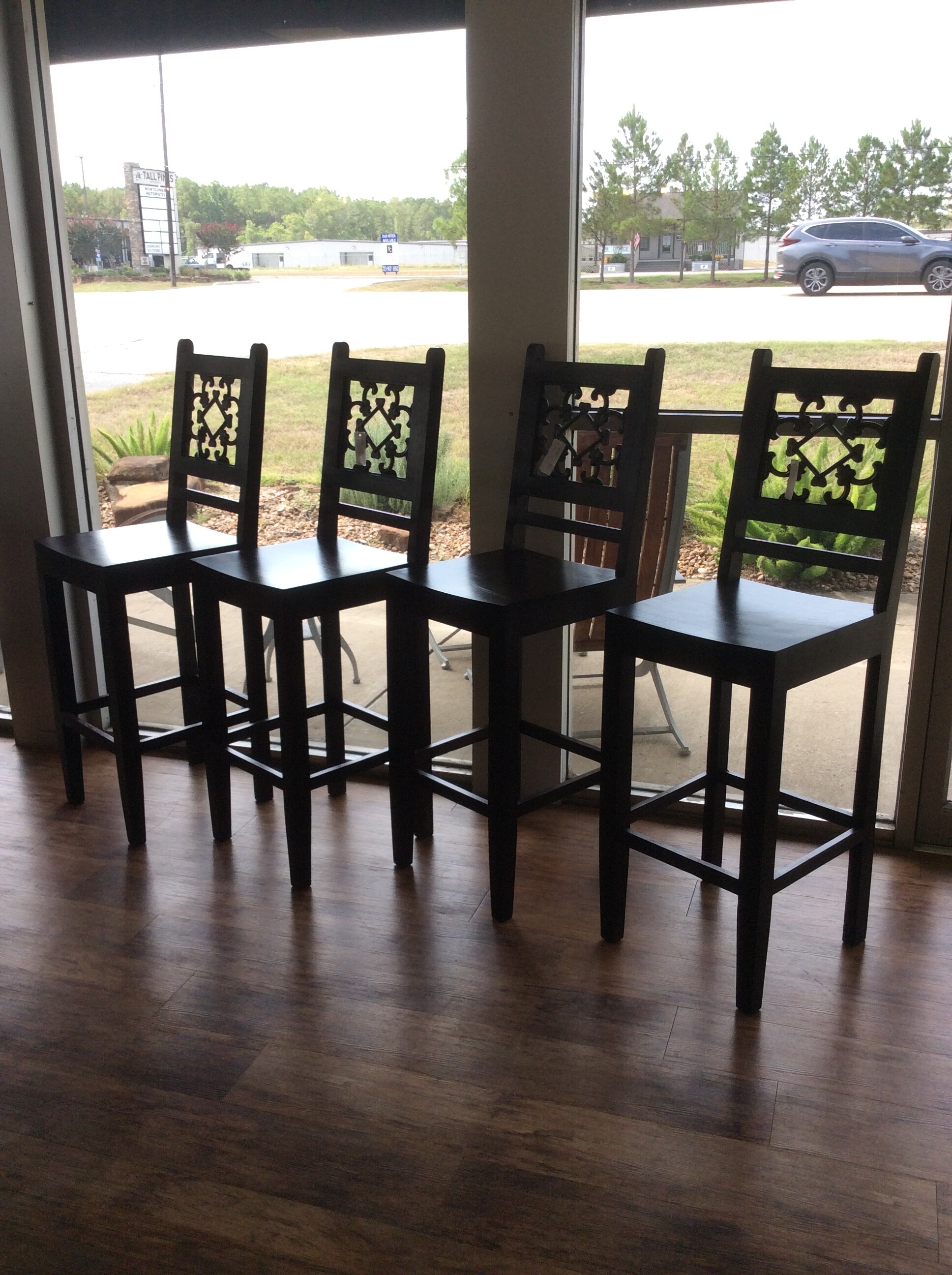 This is a set of 4 black bar stools with a swirle design on the back.