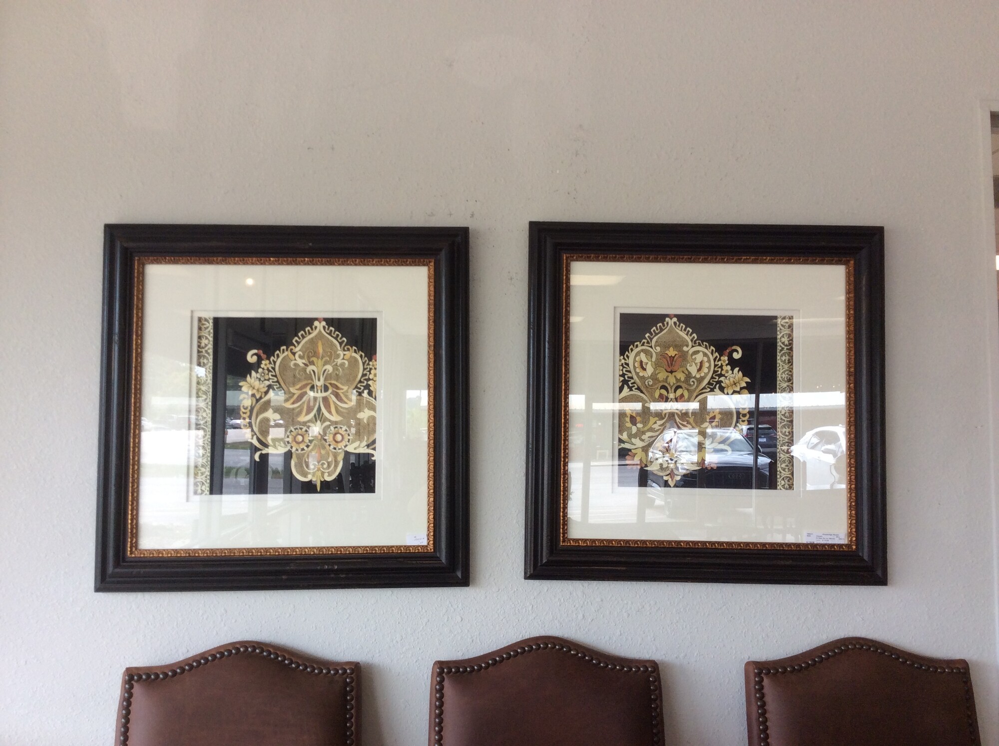 This is a pair of Fleur De Lis pictures, framed in a gold and black frame.
