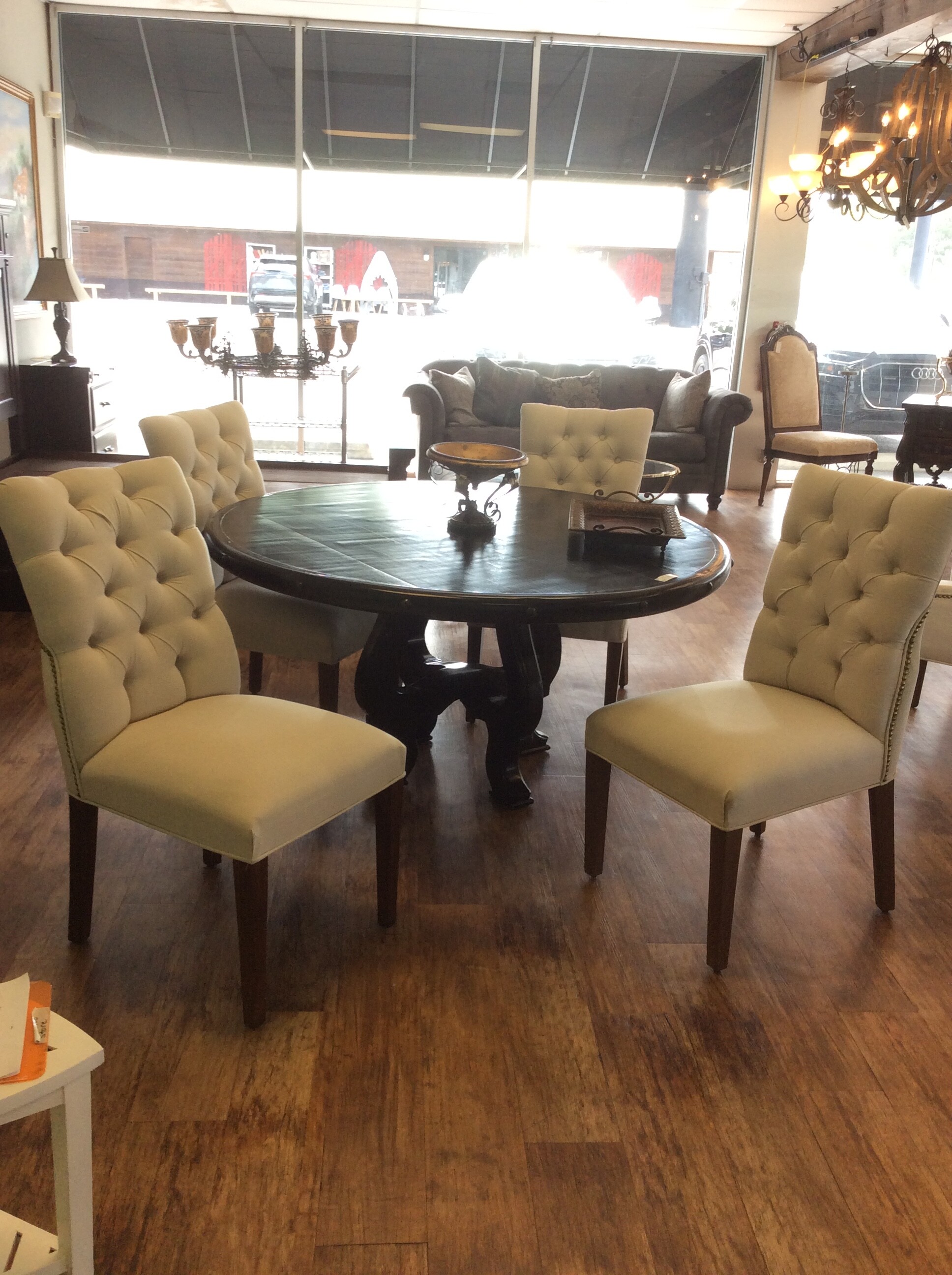 This is a set of 4 beige, upholsterd, tuffed dinning chairs. These chairs have dark brown legs and nailhead trim.