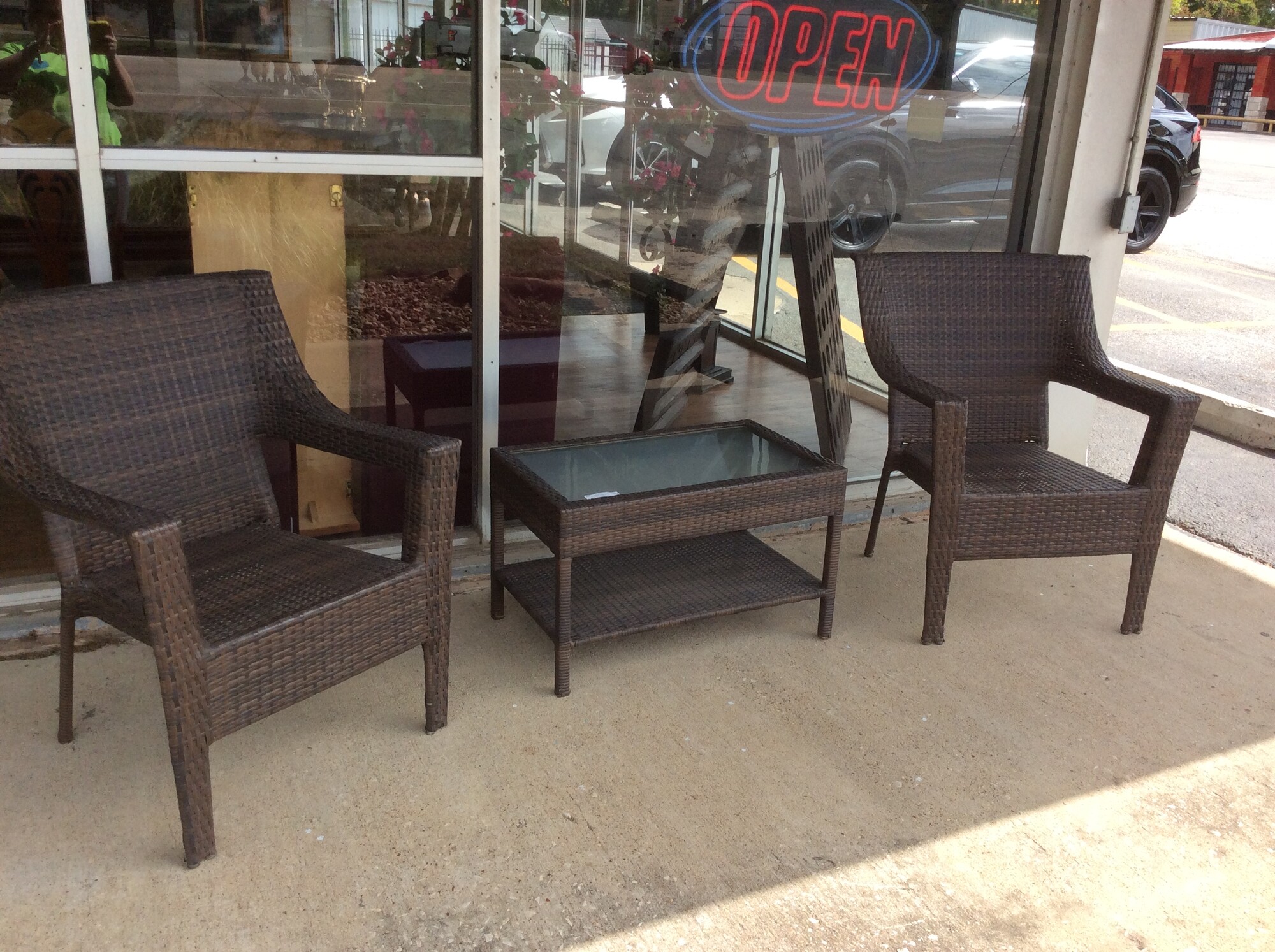 This is a 3 piece, wicker type, brown patio set. This set has 2 arm chairs and a coffee table with a glass top.