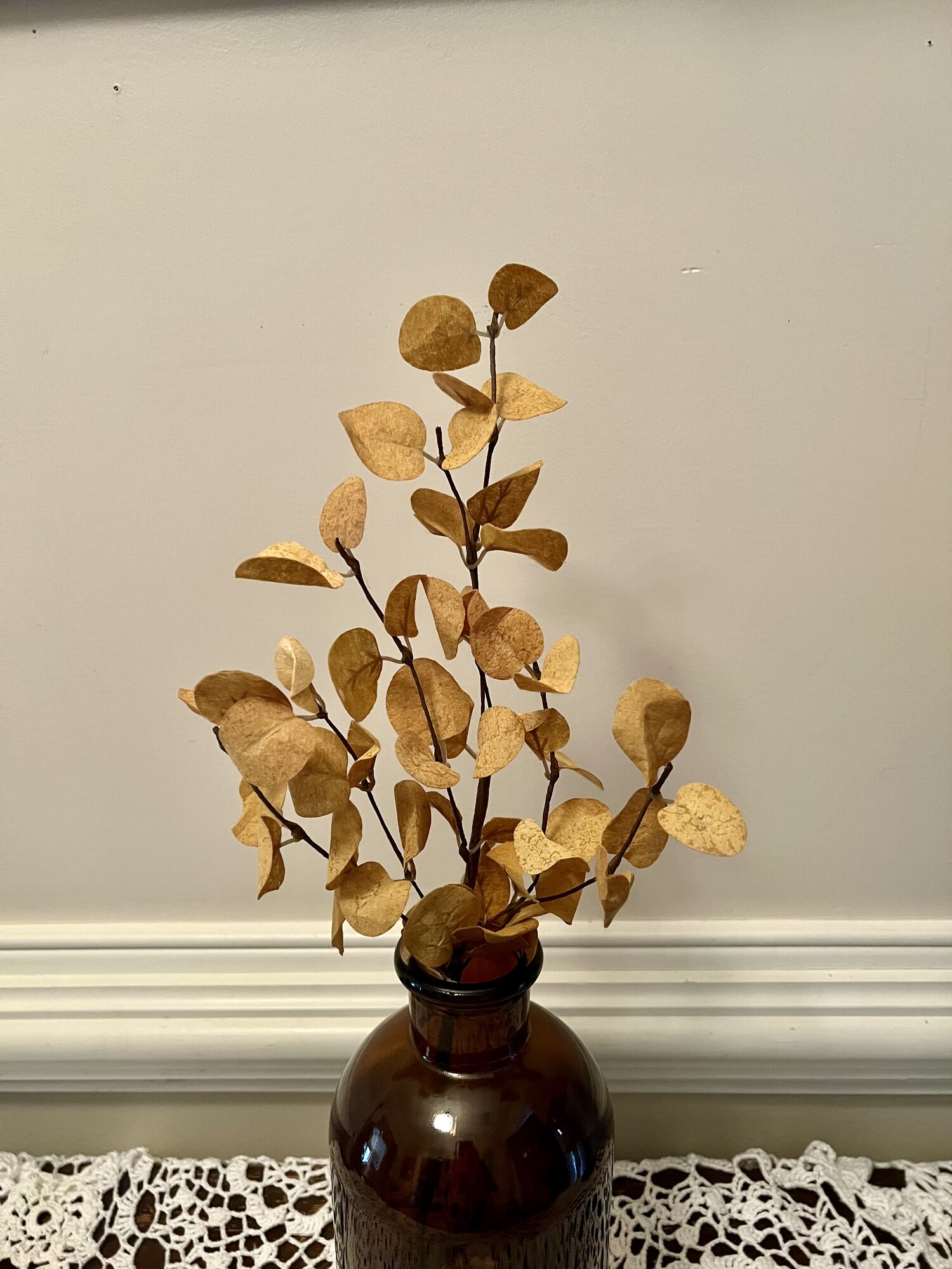 The Mustard Penny Leaf Pick  has fabric leaves and a beautiful deep mustard hue ideal for adding a touch of fall to any space. Pair this pick with cotton, hops or millet for a harvest centerpiece.  Measures 18 inches high and 4 inches wide