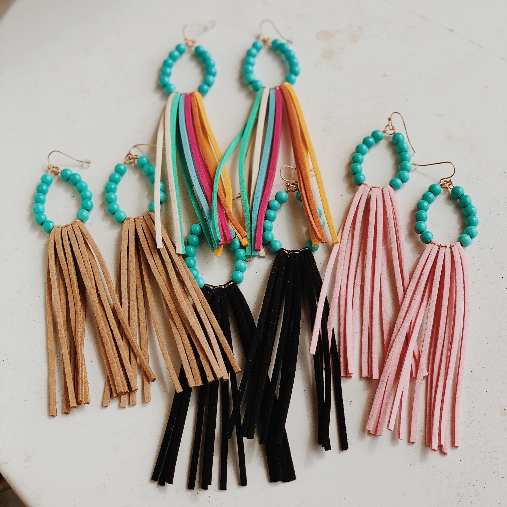 These beautiful tassel earrings are available in pink, tan, rainbow, or black! They measure 5 inches in length.