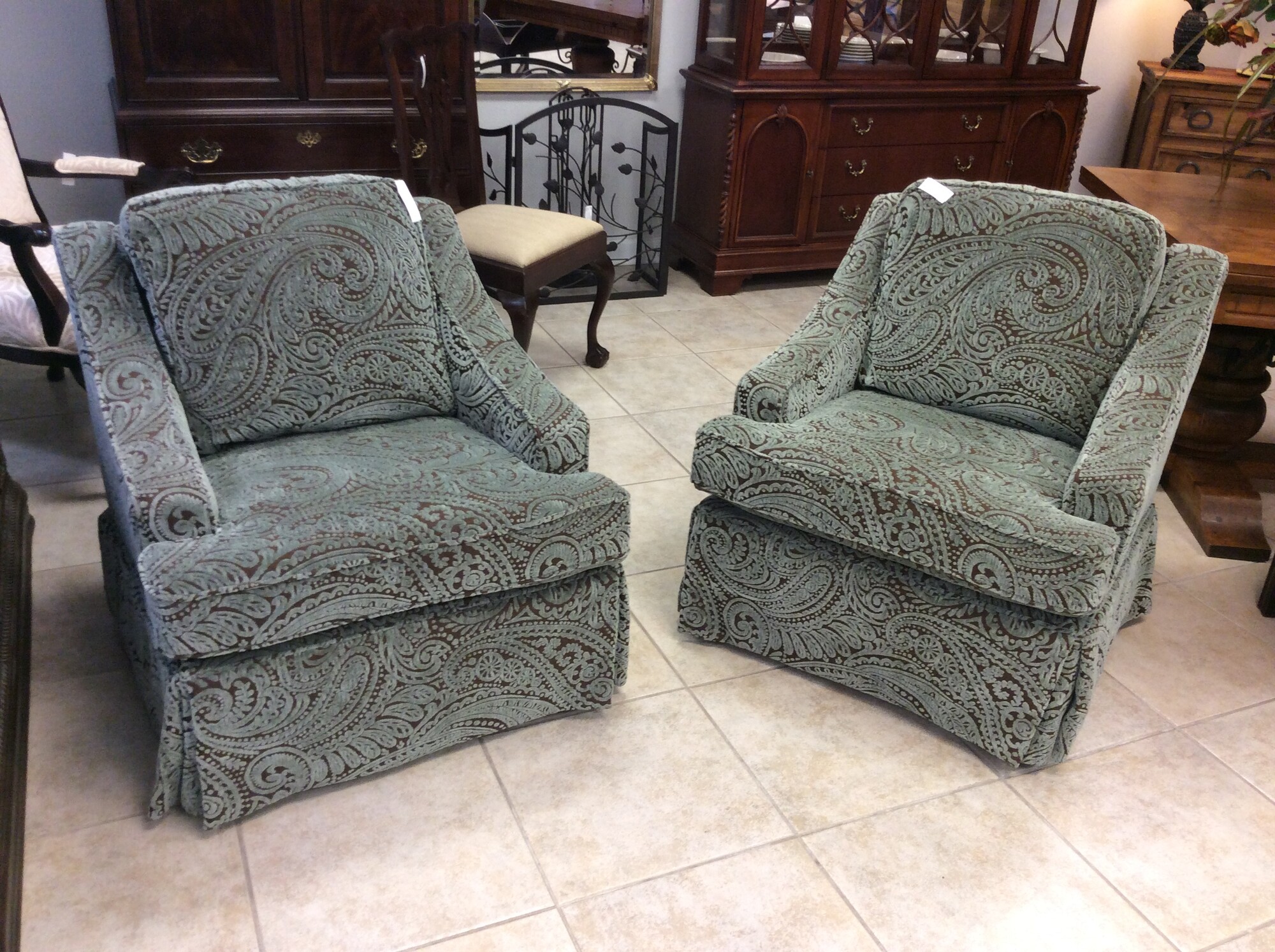 This is a pair of beautiful aqua and brown paisly swivel chairs.