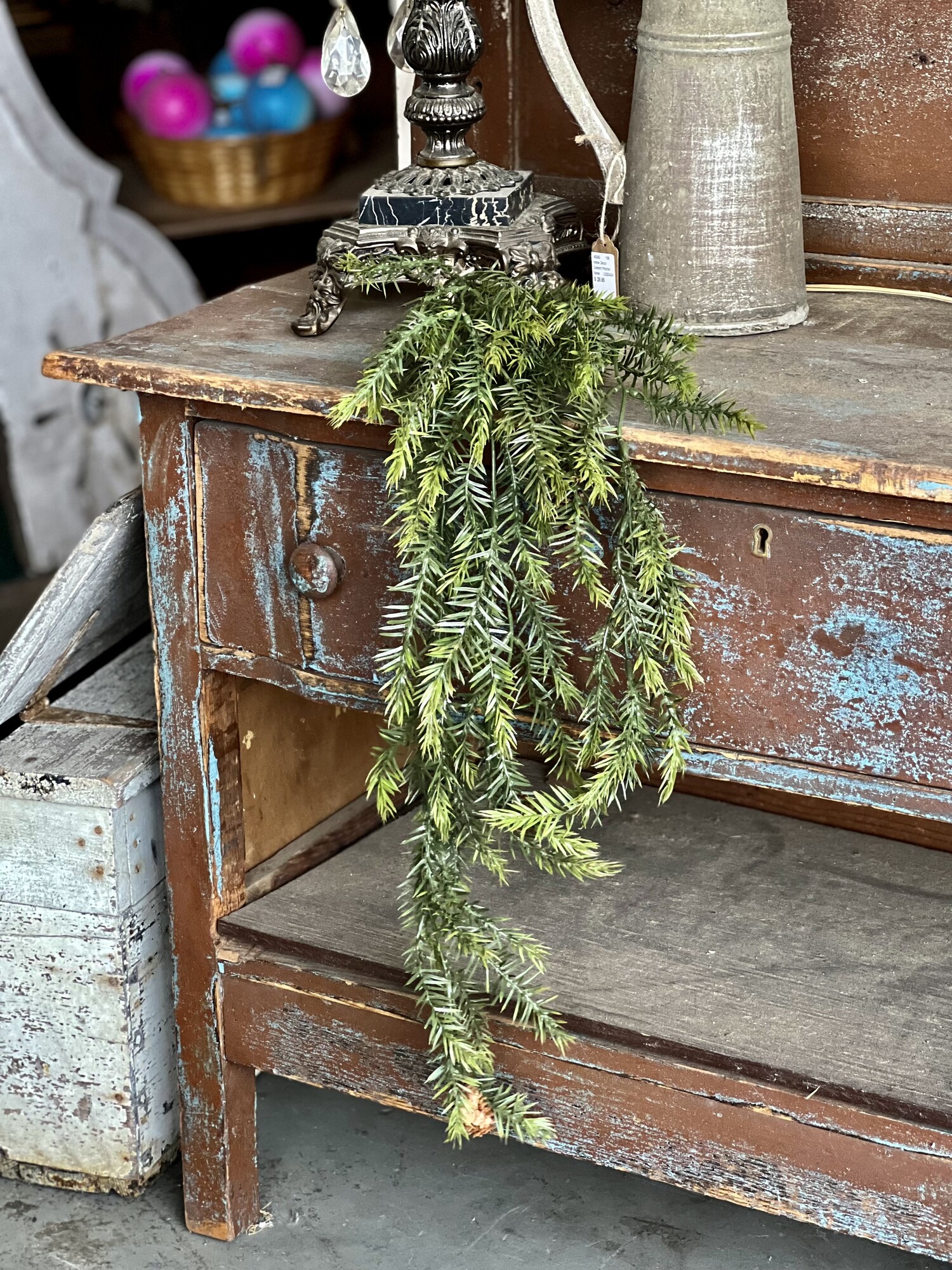 Spruce Hanging Bush features airy, plastic spruce needles with pinecones.The realistic bush is perfect for displaying during the holiday season, but it can also be used all year long to add a rustic, earthy element to any room decor. It is 34 inches long