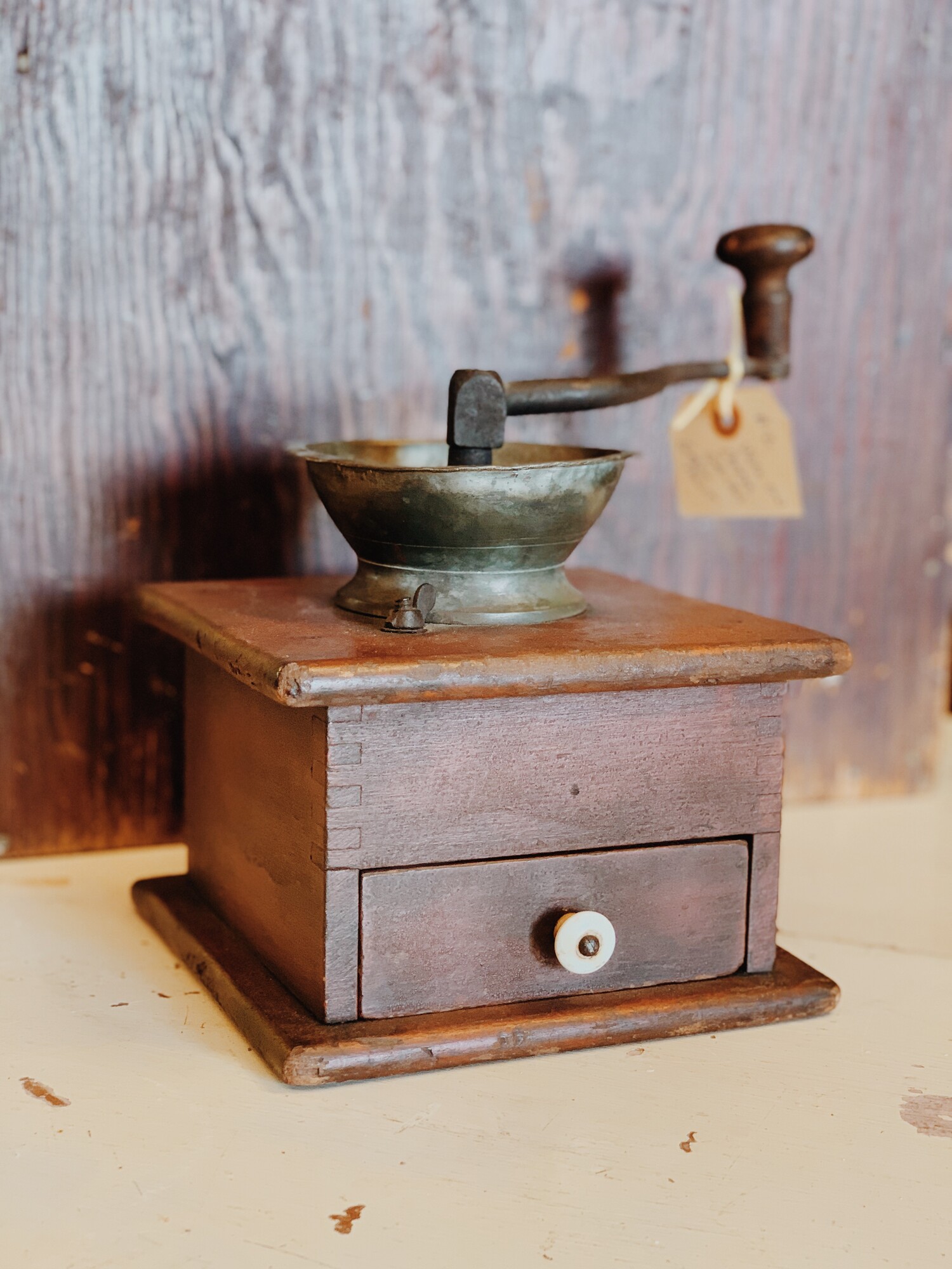 This antique coffee grinder is such a cool piece! It looks stunning on shelves, counters, and tables. This is a manual grinder and has a removable, wooden grounds catcher.

Measurements: 10 Inches (Height from bottom to handle) x 7.5 Inches x 7 Inches