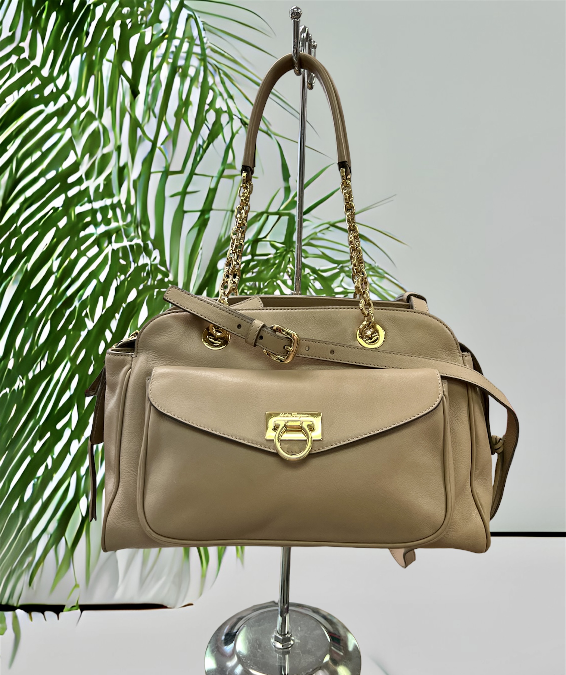 FERRAGAMO
Gancini Pocket Chain Bowler Bag Leather Medium

Designer: Salvatore Ferragamo
Dimensions: Height: 9.5 in (24.13 cm)Width: 13 in (33.02 cm)Depth: 5 in (12.7 cm)
Period: 21st Century
Material Notes:
Exterior Material: Leather Exterior Color: Beige
Interior Material: Fabric Interior Color: Beige
COMES WITH CERTIFICATE OF AUTHENTICITY

About the Designer:
Salvatore Ferragamo Clothing
A perfectionist who as a child crafted a pair of white shoes for his sister’s first holy communion because his parents couldn’t afford new footwear, Salvatore Ferragamo was ambitious from his earliest days. The young Italian shoemaker established in the years that followed what would one day become a fashion empire — the highly profitable multinational family-owned and -operated luxury brand today counts more than 600 stores in 96 countries around the world, and vintage Salvatore Ferragamo shoes, belts, handbags and other clothing and accessories are objects of desire for fashion lovers everywhere.

Salvatore Ferragamo sought an education in the art of shoemaking when he was eleven — he apprenticed with a local shoemaker and spent a short time in nearby Naples learning what he could at a shoe factory. He opened his first shop with a handful of workers the following year, and in 1914 — when he was still a teenager — Ferragamo emigrated to America, just as his siblings had before him, seeking new opportunities for work and to learn in the footwear trade.

After securing a job at the Plant Shoe Factory in Boston, Massachusetts, Ferragamo was uninspired by machine-made footwear. He moved across the country to Santa Barbara, California. Owing to a connection he made with a then-actor cousin, Ferragamo found work with the American Film Manufacturing Company. He made women’s shoes and provided durable cowboy boots for a film crew’s costuming department. Ferragamo’s reputation in the world of Hollywood cinema soon broadened, and he established a storefront in Mission Canyon where he made shoes by hand for the likes of actresses Gloria Swanson, Greta Garbo and Dolores del Río.

By the 1920s, film directors commissioned Ferragamo to produce shoes for a range of movies — the list of films eventually included The Ten Commandments, The Covered Wagon and The Thief of Baghdad. When he felt comfortable enough with the English language, Ferragamo also enrolled in anatomy courses at the University of Southern California in Los Angeles in order to better understand motion and the demands that we place on our footwear.

By the late 1920s, Ferragamo sought to expand production of his shoes and returned to Italy. He hired scores of apprentices to work in a factory in Florence, where Ferragamo carefully melded the principles of handcraftsmanship with all that he learned about America’s shoe factories. He filed patents — hundreds over the years — on the steel shank arch and many other unique aspects of his shoe design, and when economic and political influences during the 1930s forced Ferragamo to substitute pressed cork for steel to support the arch, the wedge heel was born. Other creative materials he integrated into his forward-looking creations were hemp, felt, nylon fishing line, fish skin and cellophane twisted with silk.

In the late 1940s, the brand’s first storefront opened in Manhattan, and today Salvatore Ferragamo is known worldwide and is synonymous with a wealth of iconic footwear such as Viva ballet flats, Vara Bow pumps, Gancini loafers and lots more. Ferragamo’s son, Ferruccio, was appointed CEO in 1984. Under his leadership, Ferruccio diversified and expanded the fashion business further, getting into sunglasses, fragrance, watches and made-to-measure men’s shoes. Ferruccio was succeeded by his brother, Leonardo Ferragamo, and British designer Maximilian Davis is now creative director of the brand.