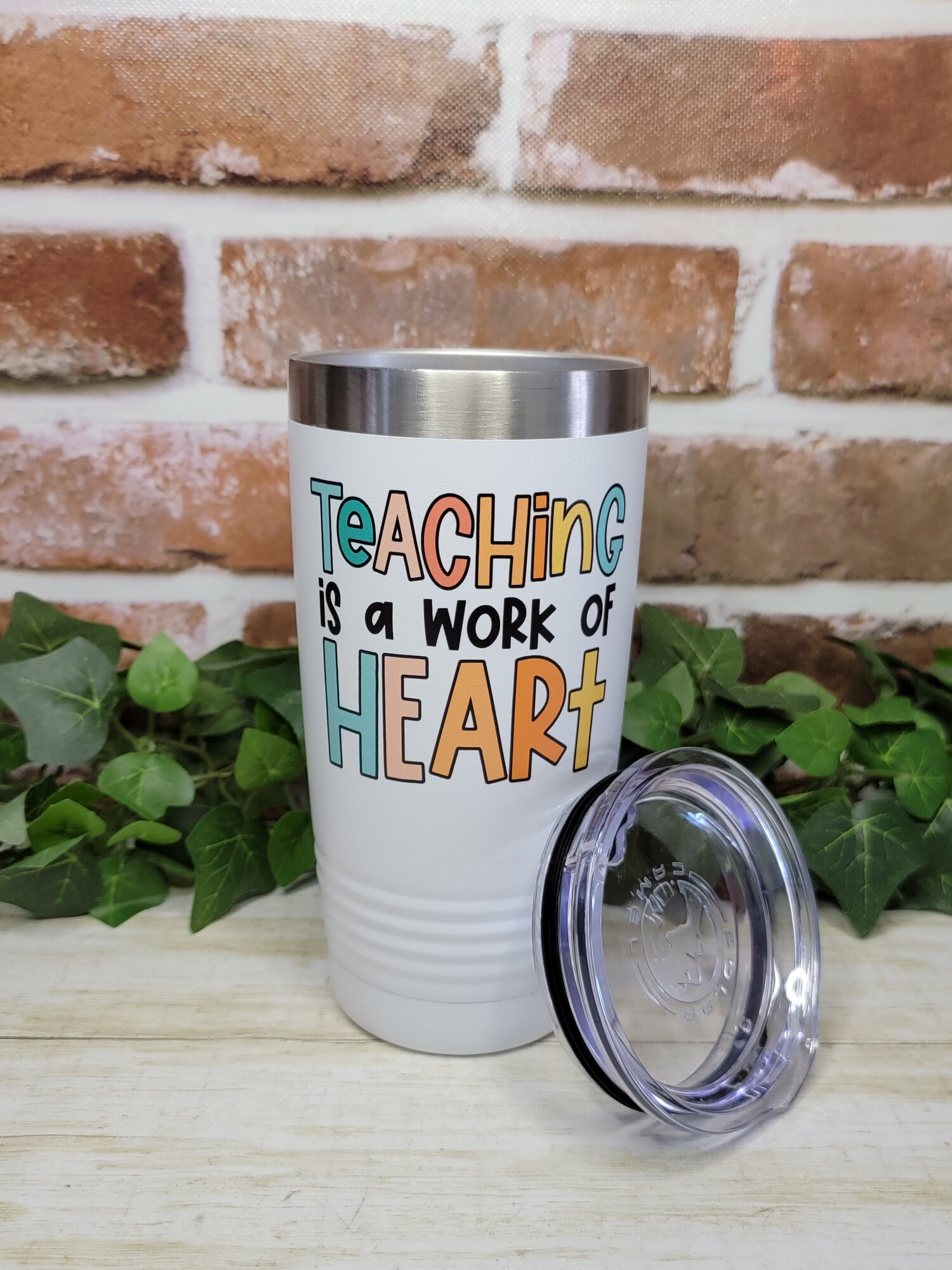Teaching is a Work of Heart. Our custom printed tumbler will make a great gift for that teacher in your life. They will keep that special teachers coffee or cocoa warm for hours.

Our Tumblers are powder coated and stainless steel; double wall vacuum insulated. Keep your drinks ice cold longer and it is great for hot beverages. The clear lid even allows for use of straws!- Double wall 18/8 stainless steel construction

- Features copper insulation that keeps drinks HOT for 8 hours and COLD for 16 hours
- Tapered design that easily fits in cup holders
- Clear push-on lid
- No sweat Exterior
- Hand wash recommended

We UV Print the cups; so there is no worries of a vinyl decal peeling or coming off.