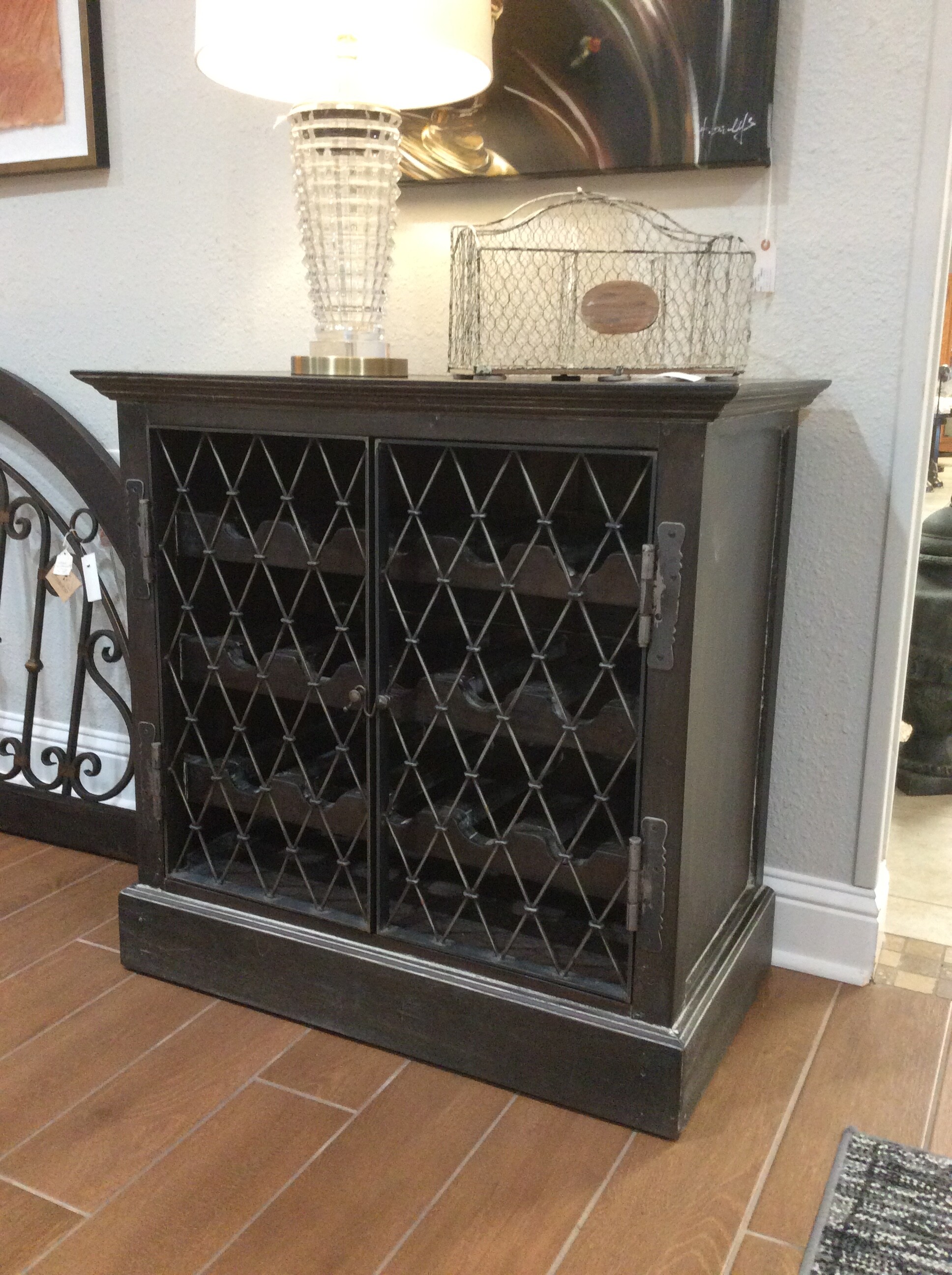 This is a very cool and attractive wine cabinet! A lovely combination of wood and metal - it's been painted and distressed for that weathered, timeless, vintagy look.  It's also compact in size yet holds 15 bottles of vino.