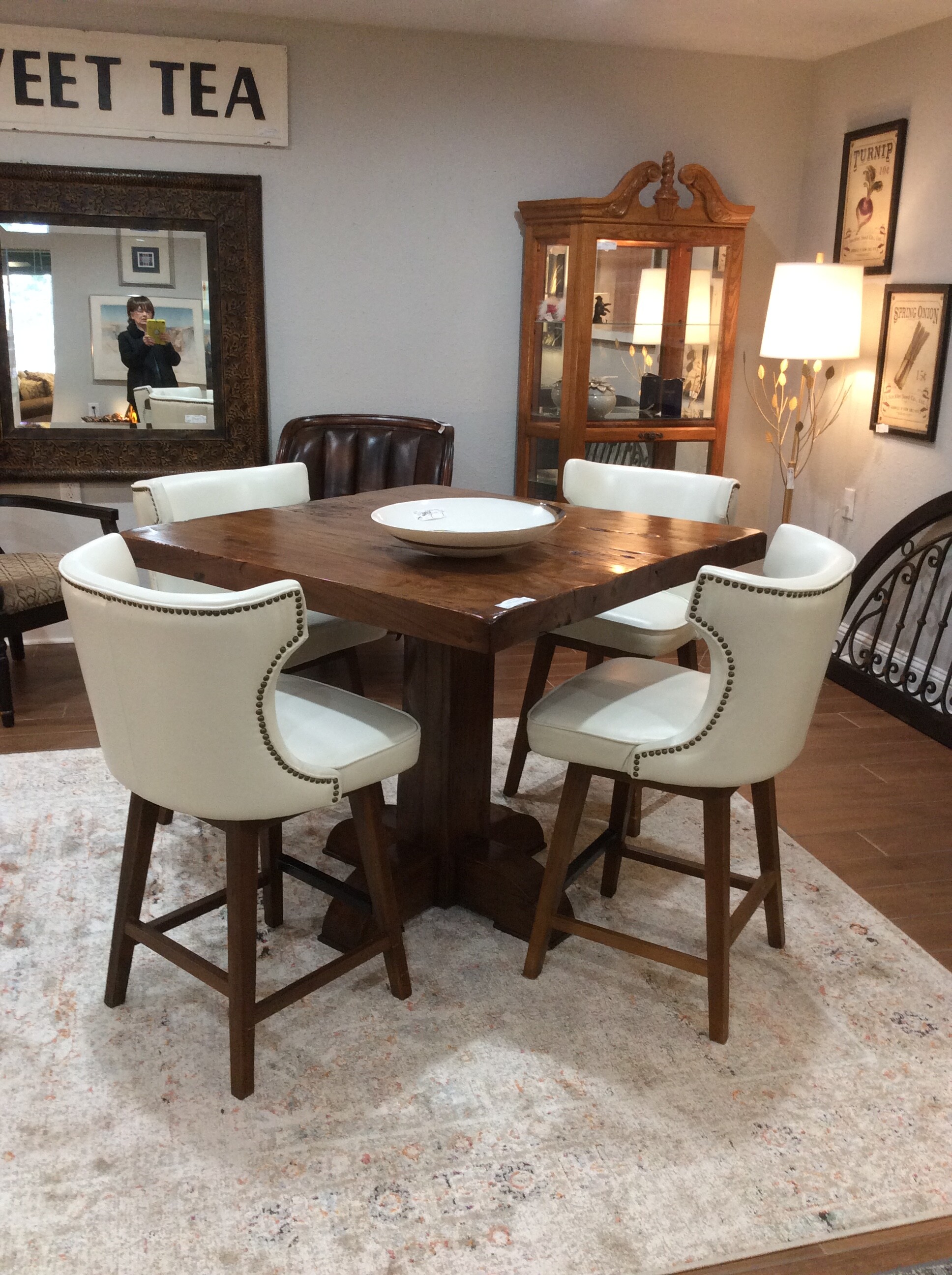 This is a great set! This is a counter-height table with 4 upholstered chairs. The table has a rough-hewn top with a solid, squared off pedestal base. The chairs are more contemporary in style, are upholstered in off-white and have a nailhead trim.