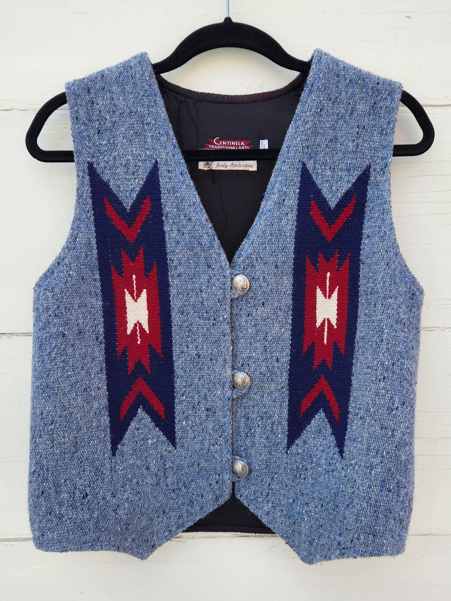 Vintage Centinela Traditional Arts Hand-woven Wool Vest size 36
This style of vest has been done for many years in Chimayo. This Vest was hand-woven by Jody Anderson. It consists of some variation of Chimayo designs on front and back panels. Blue Wool with red, white and navy included in its design. Three 1 inch pewter buttons.  Size is missing but it is the size of a 36.
Pit to Pit 19 inches across
Waist 19 inches across
Down the back 20 inches
EUC
Retail $360