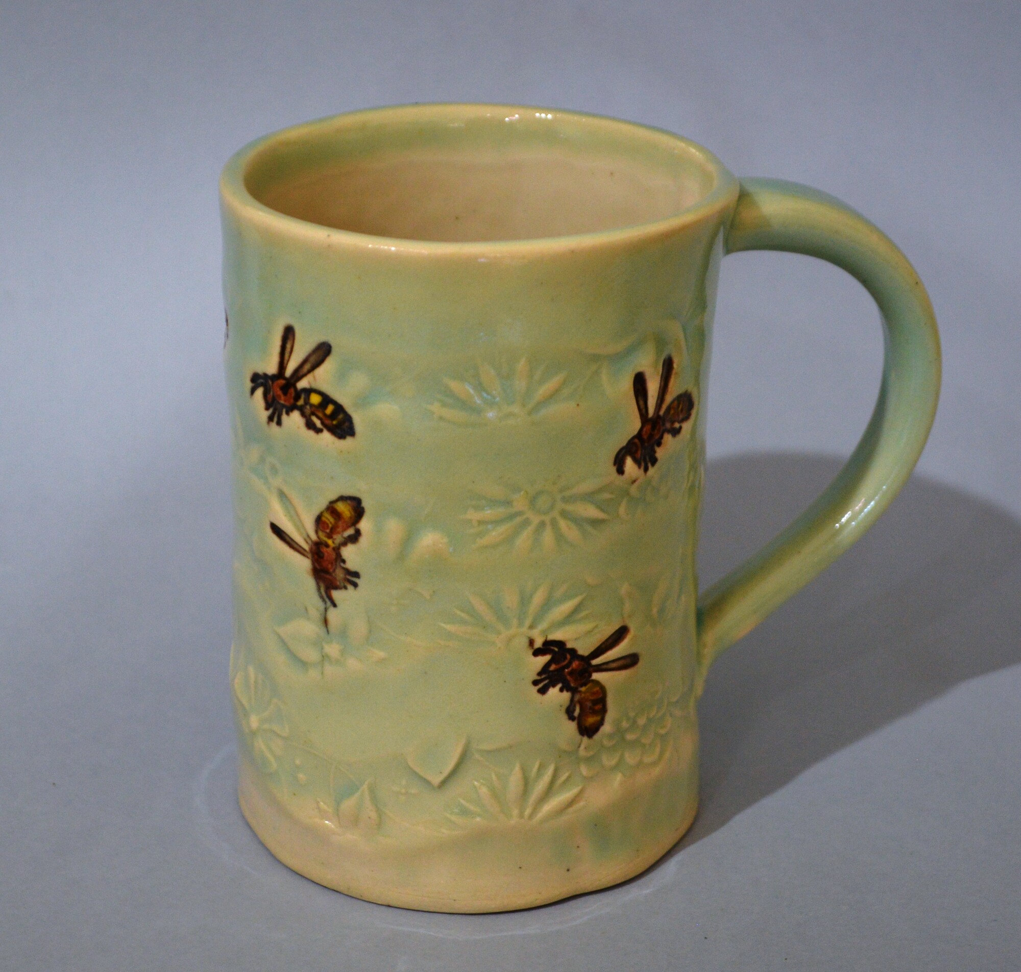 Green Bee Mug
Pam Gray
Pottery
12 oz handmade ceramic mug with light green glaze and bees motif.  Micorwave and dishwasher safe but hand washing is recommended.
