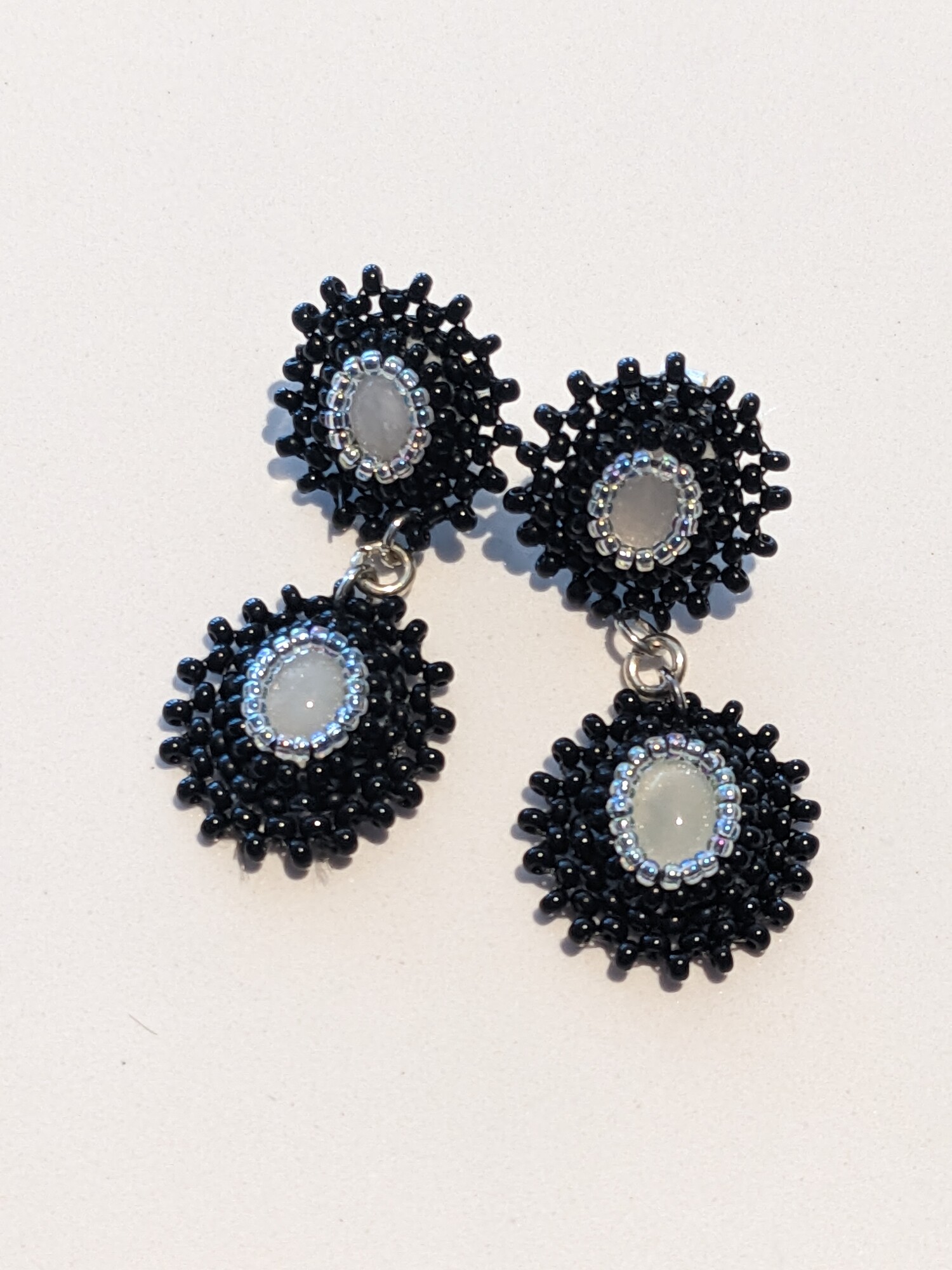Double Agate Star Earrings
Jama Watts
Jewelry (Bead Embroidery)
2.25 in long by .75 in wide
Two white agate cabochons surrounded by black and silver-lined seed beads.  Backed by black leather.  Stainless steel posts.