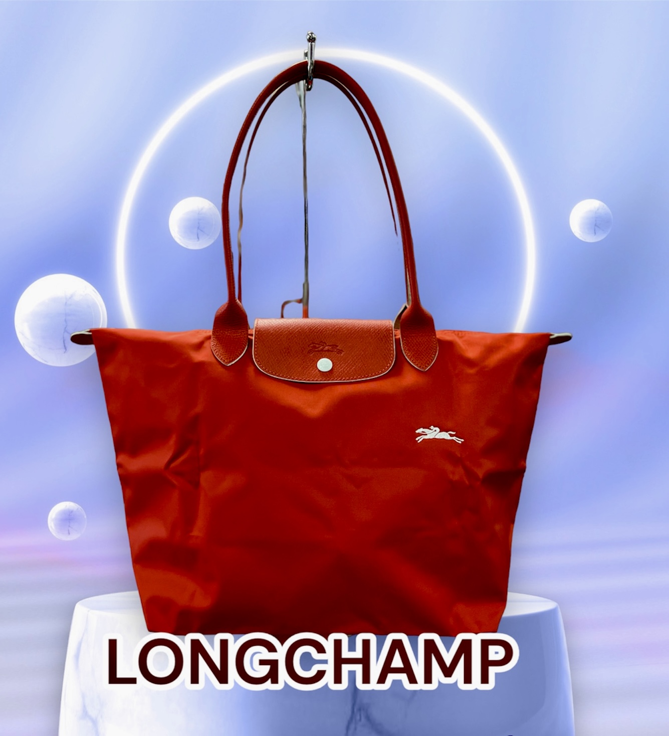 LONGCHAMP
Le Pliage Tote
Original Retail: $155.00

Smooth, sleek red nylon and embossed leather trim make this spacious tote a no-brainer for everyday versatility and elegance.
This bag is preowned, in like new conditions.  Does not appear to ever of been used.  Spotless interior and exterior.
Water-resistant lining
Textile with leather trim
12 1/4”W x 11 3/4”H x 7 1/2”D.
9\" Strap Drop
*******In 1948, Jean Cassegrain turned his Paris tobacco shop—where he was known to cover his pipes in an exquisite leather—into an accessories business. Named after the famed horse track on the outskirts of Paris, Longchamp is still family owned and operated, creating superbly crafted handbags and luggage lauded for a decidedly understated, always chic look.